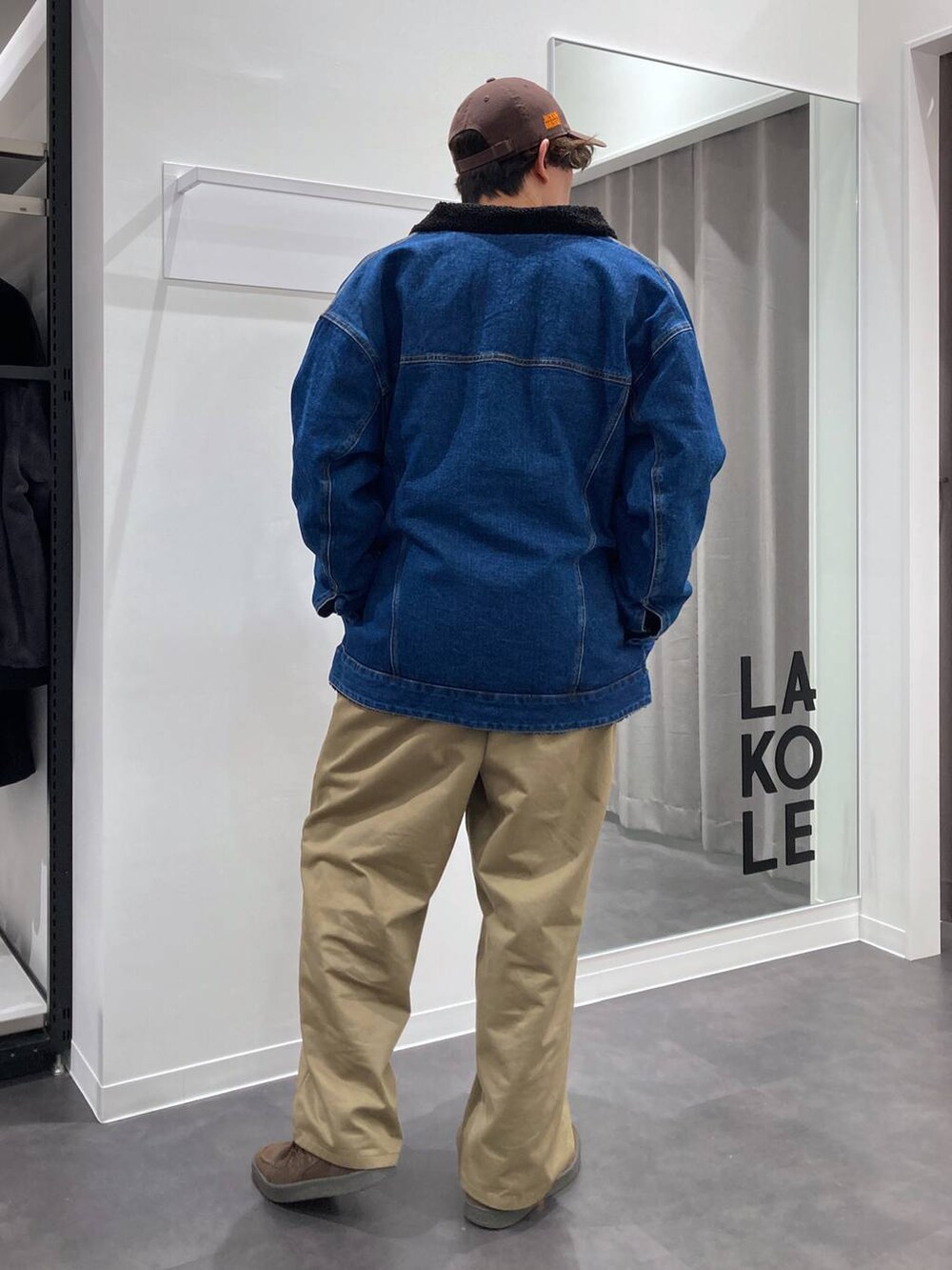 ブルー系のデニムジャケット、ベージュ系のチノパンツ、オレンジ系のニット/セーターを着用したメンズの冬コーディネートの2枚目の写真