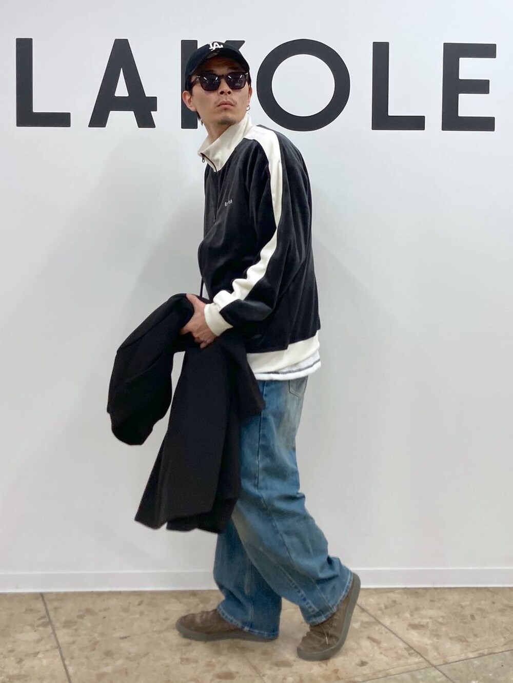 ブラック系のチェスターコート、ブルー系のデニムパンツ、ホワイト系のTシャツ/カットソーを着用したメンズの秋コーディネートの7枚目の写真
