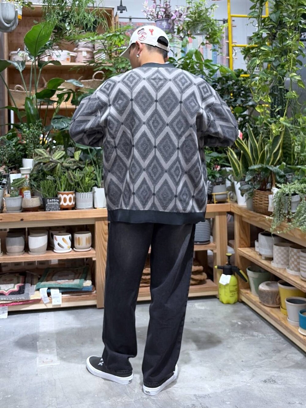 ブラック系のデニムパンツ、レッド系のTシャツ/カットソー、グレー系のカーディガン/ボレロを着用したメンズの秋コーディネートの2枚目の写真