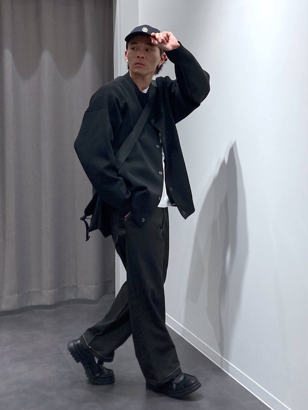 ブラック系のその他パンツ、ブラック系のローファー、ブラック系のメッセンジャーバッグを着用したメンズの冬コーディネートの3枚目の写真