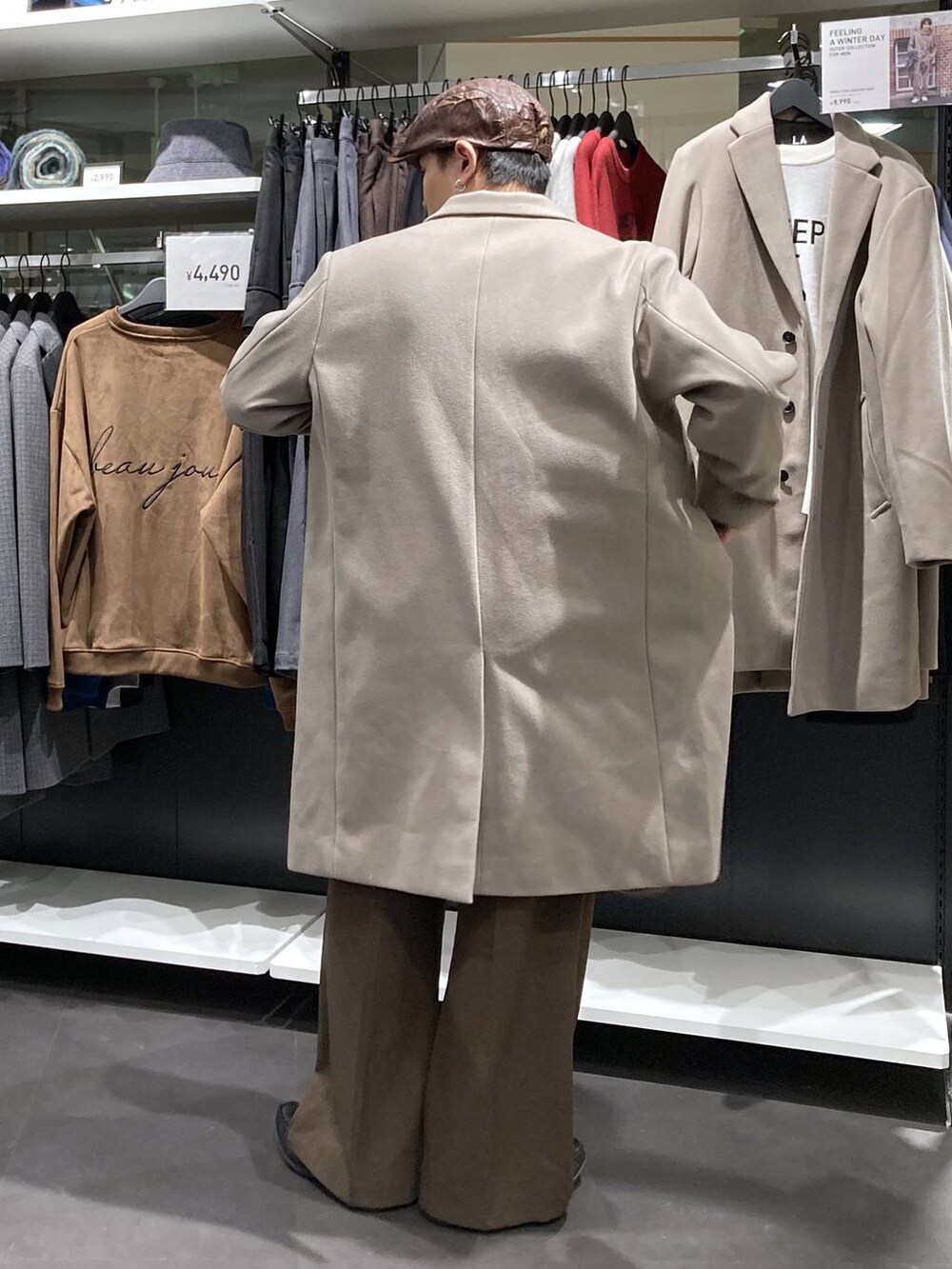 ホワイト系のチェスターコート、ベージュ系のニット/セーター、ブラウン系のその他パンツを着用したメンズの冬コーディネートの2枚目の写真