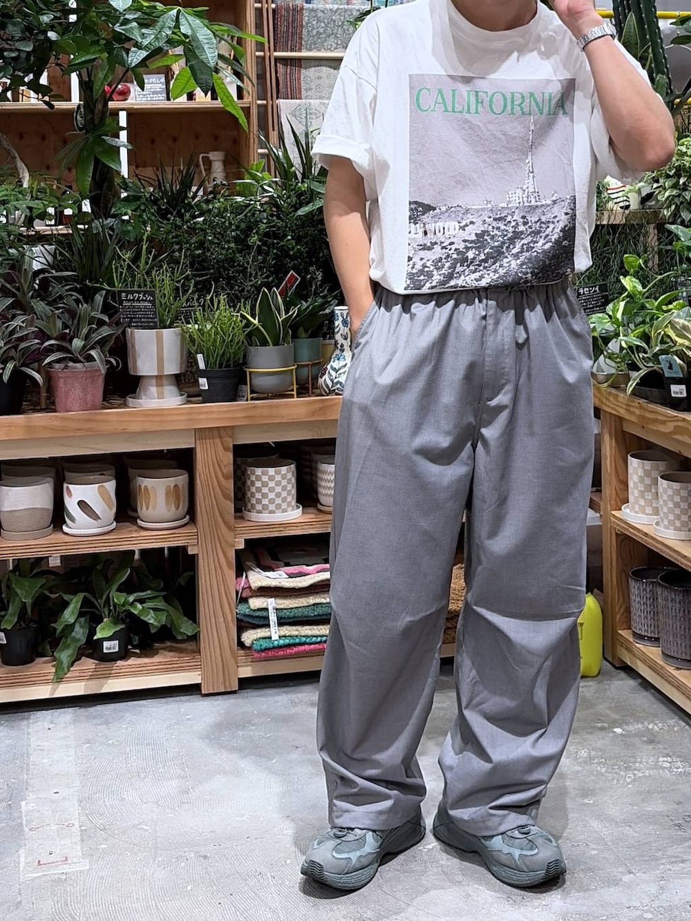 グレー系のスラックス、ホワイト系のTシャツ/カットソーを着用したメンズの夏コーディネートの7枚目の写真