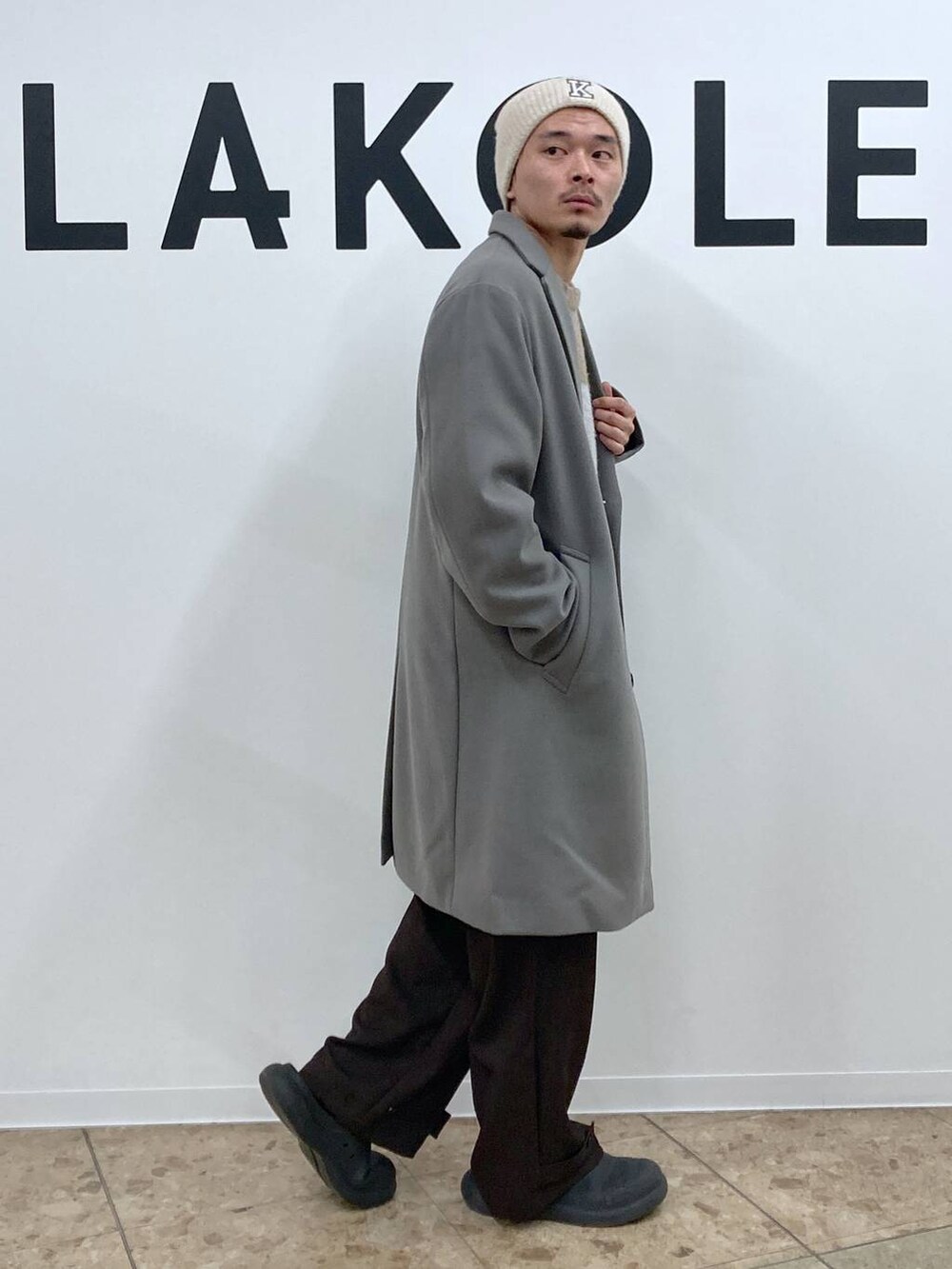 グレー系のチェスターコート、ブラウン系のカーゴパンツ、ブラウン系のニット/セーターを着用したメンズの冬コーディネートの4枚目の写真