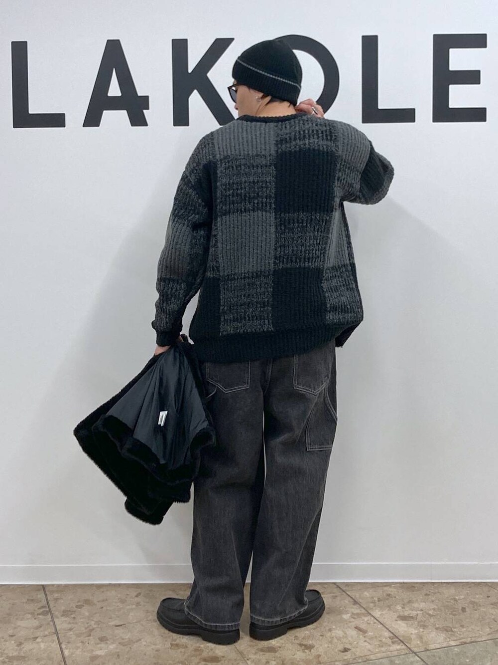 ブラック系のニット/セーター、グレー系のデニムパンツ、ブラック系のローファーを着用したメンズの冬コーディネートの6枚目の写真