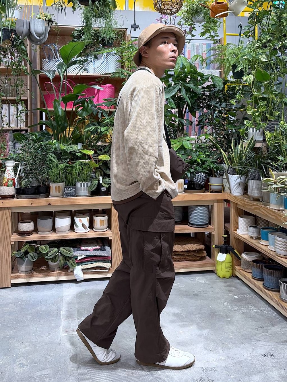 ベージュ系のTシャツ/カットソー、ブラウン系のカーゴパンツ、ベージュ系のハットを着用したメンズの秋コーディネートの4枚目の写真