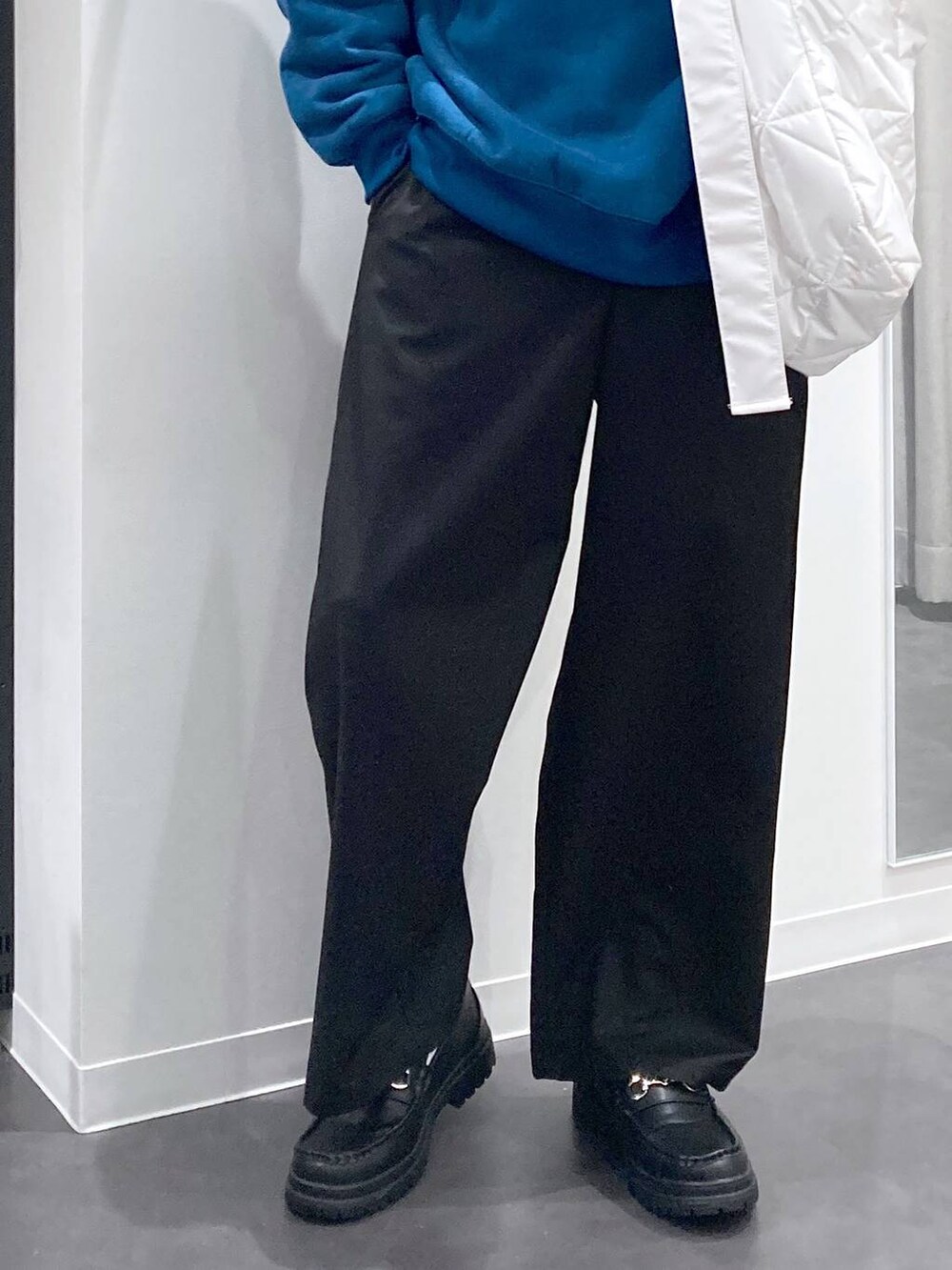 ブラック系のローファー、グリーン系のスウェット、ホワイト系のショルダーバッグを着用したメンズの冬コーディネートの9枚目の写真