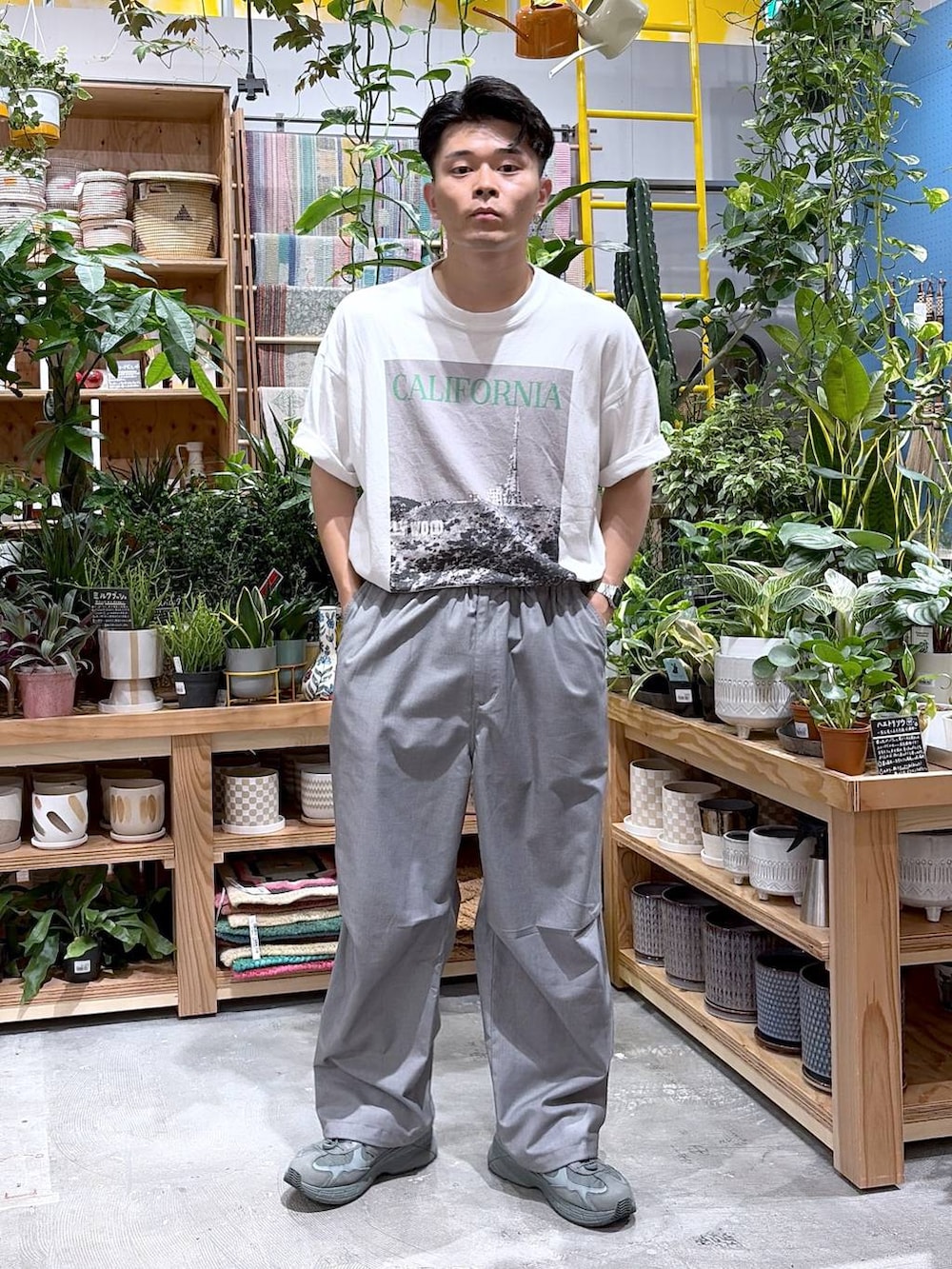 グレー系のスラックス、ホワイト系のTシャツ/カットソーを着用したメンズの夏コーディネートの8枚目の写真