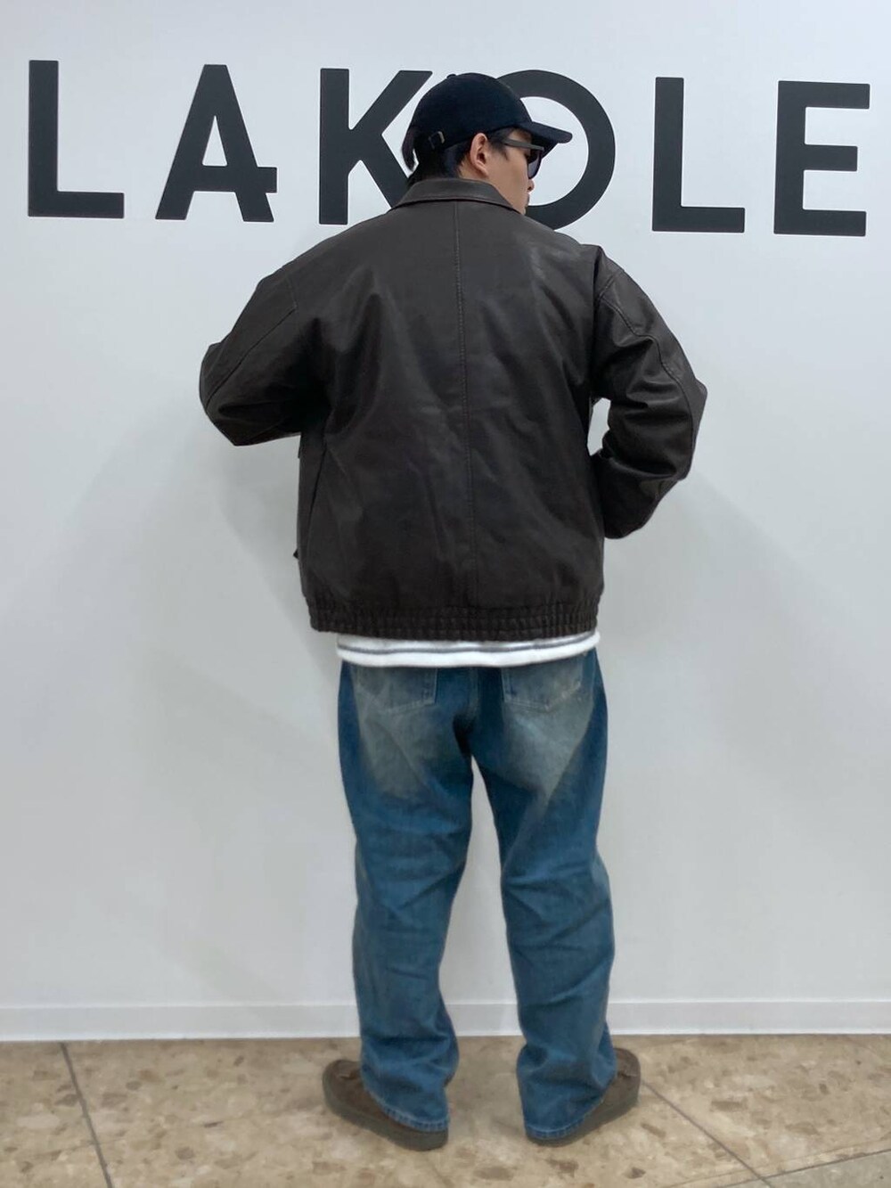 ブルー系のデニムパンツ、ホワイト系のTシャツ/カットソー、ブラウン系のブルゾンを着用したメンズの秋コーディネートの2枚目の写真