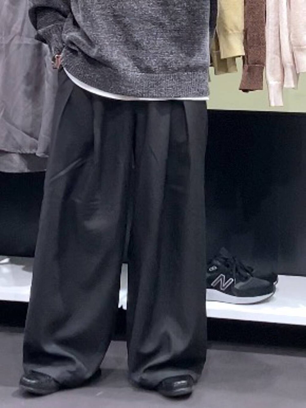 ホワイト系のTシャツ/カットソー、グレー系のニット/セーター、ブラック系のスラックスを着用したメンズの秋コーディネートの8枚目の写真