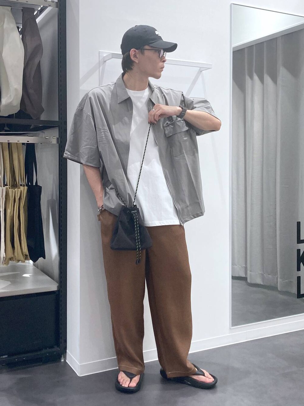 ブラック系のサンダル、ブラウン系のその他パンツ、ホワイト系のTシャツ/カットソーを着用したメンズの夏コーディネートの5枚目の写真