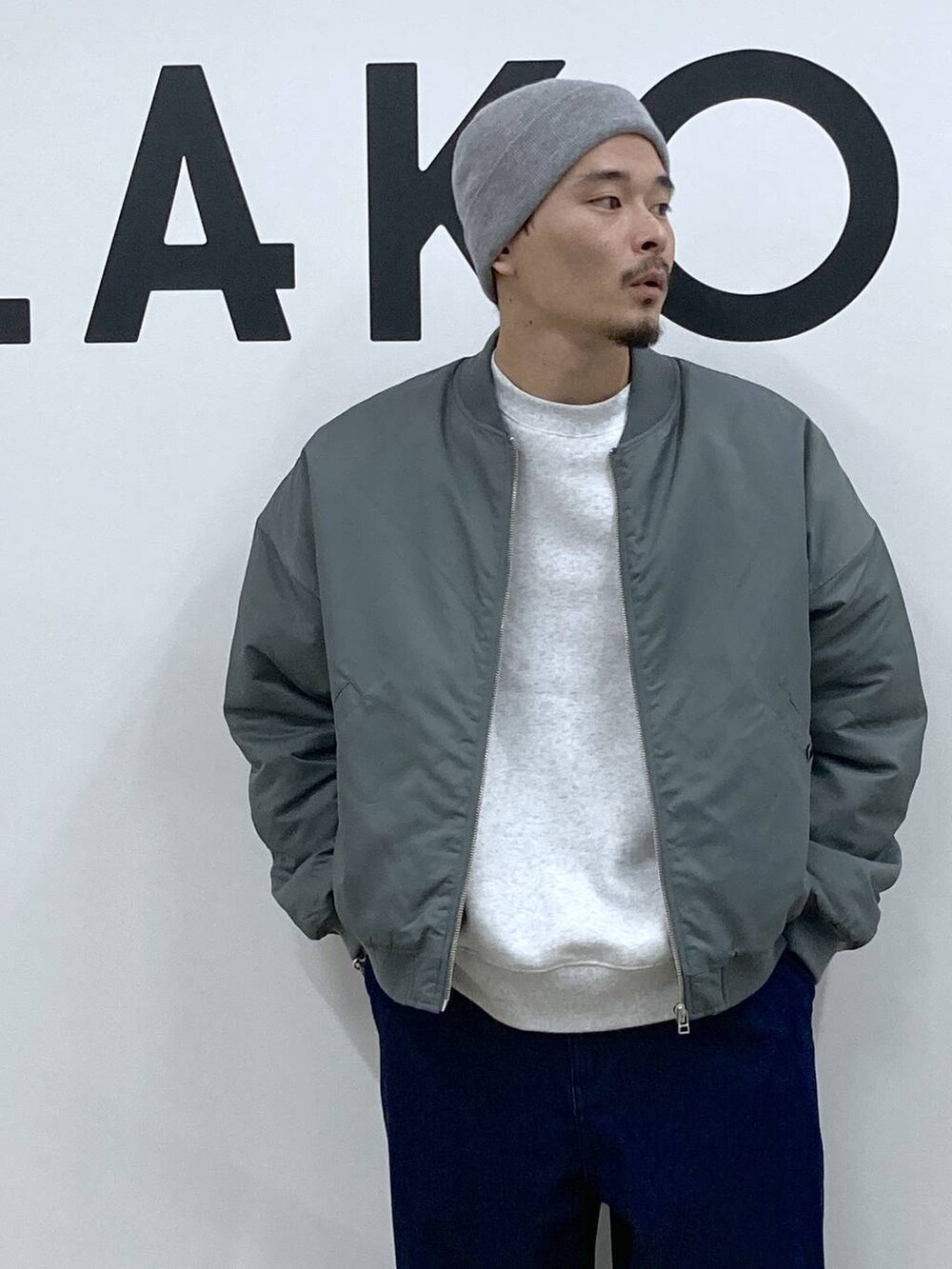 ブルー系のスニーカー、グリーン系のブルゾン、ブルー系のデニムパンツを着用したメンズの冬コーディネートの8枚目の写真