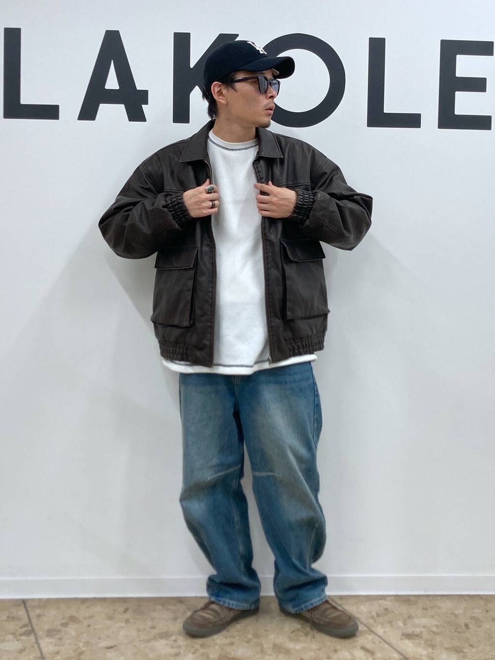 ブルー系のデニムパンツ、ホワイト系のTシャツ/カットソー、ブラウン系のブルゾンを着用したメンズの秋コーディネートの3枚目の写真