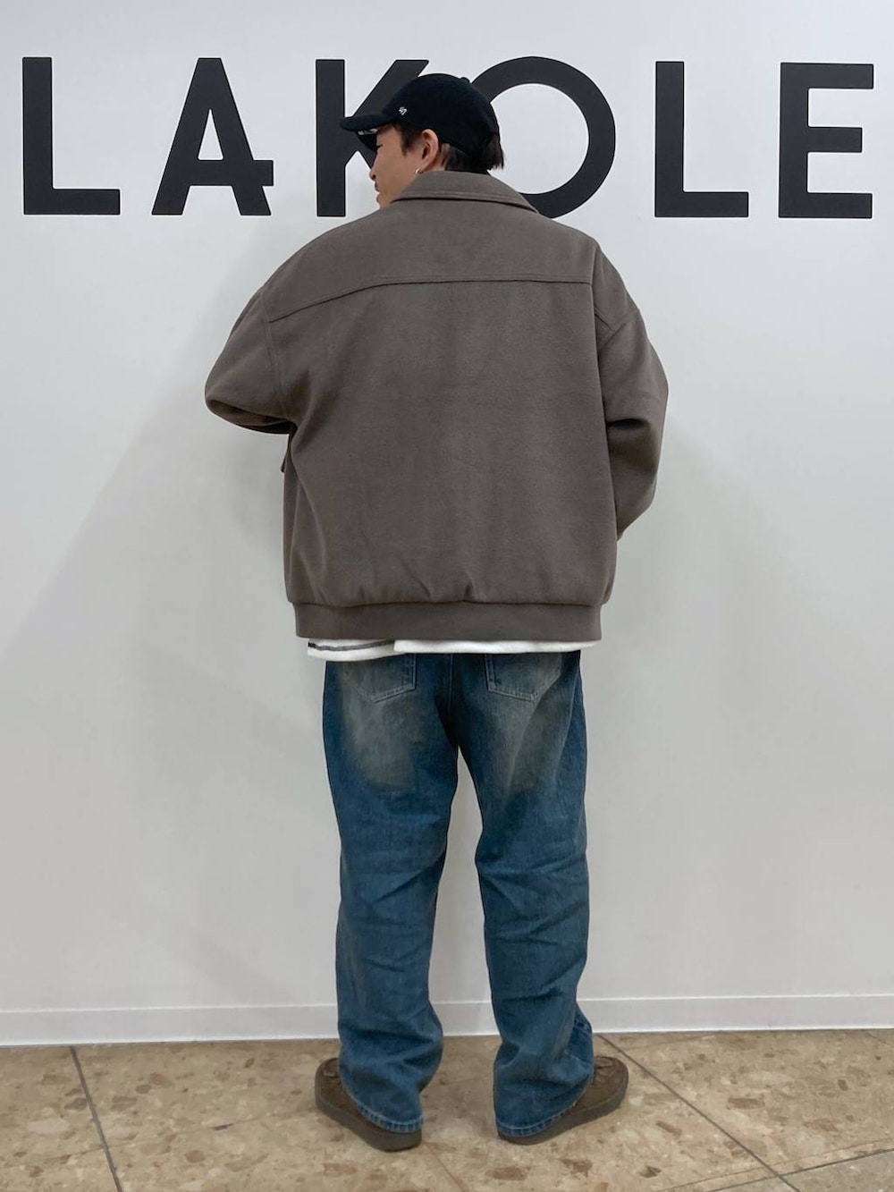 ブラウン系のブルゾン、ブルー系のデニムパンツ、ホワイト系のTシャツ/カットソーを着用したメンズの秋コーディネートの2枚目の写真
