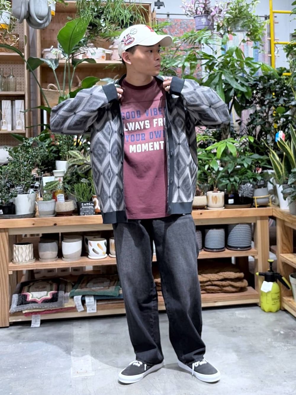 ブラック系のデニムパンツ、レッド系のTシャツ/カットソー、グレー系のカーディガン/ボレロを着用したメンズの秋コーディネートの7枚目の写真