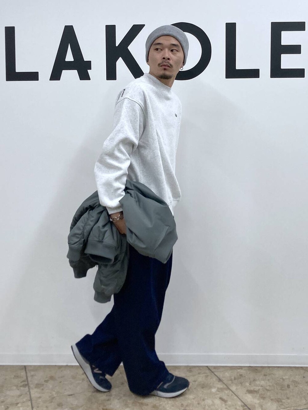 ブルー系のスニーカー、グリーン系のブルゾン、ブルー系のデニムパンツを着用したメンズの冬コーディネートの6枚目の写真