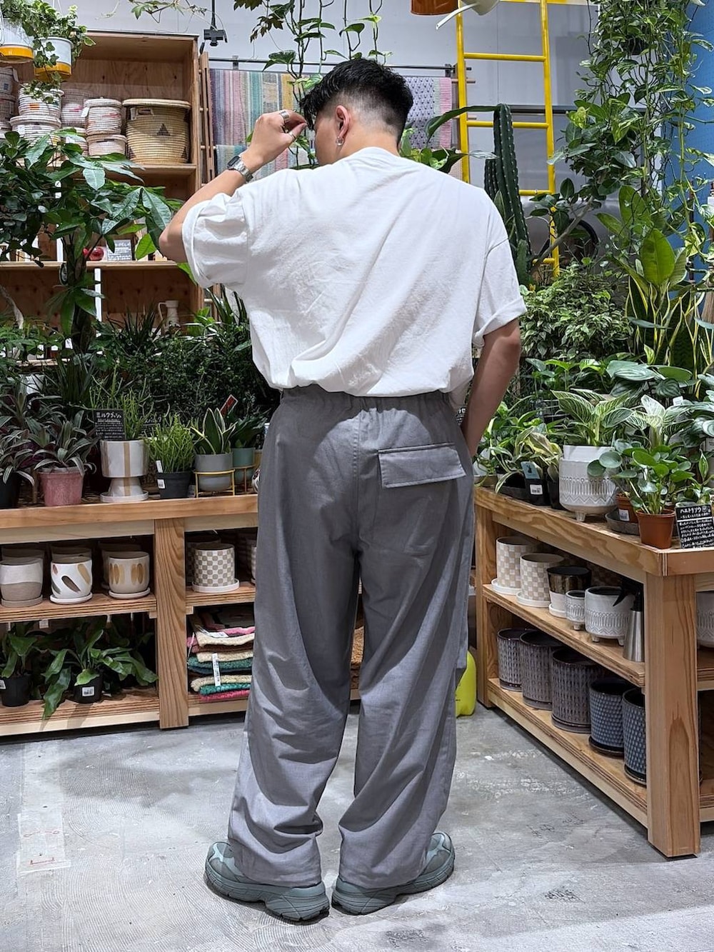 グレー系のスラックス、ホワイト系のTシャツ/カットソーを着用したメンズの夏コーディネートの2枚目の写真
