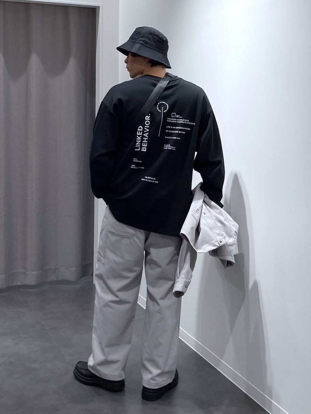 グレー系のその他パンツ、ブラック系のローファー、ブラック系のショルダーバッグを着用したメンズの冬コーディネートの6枚目の写真