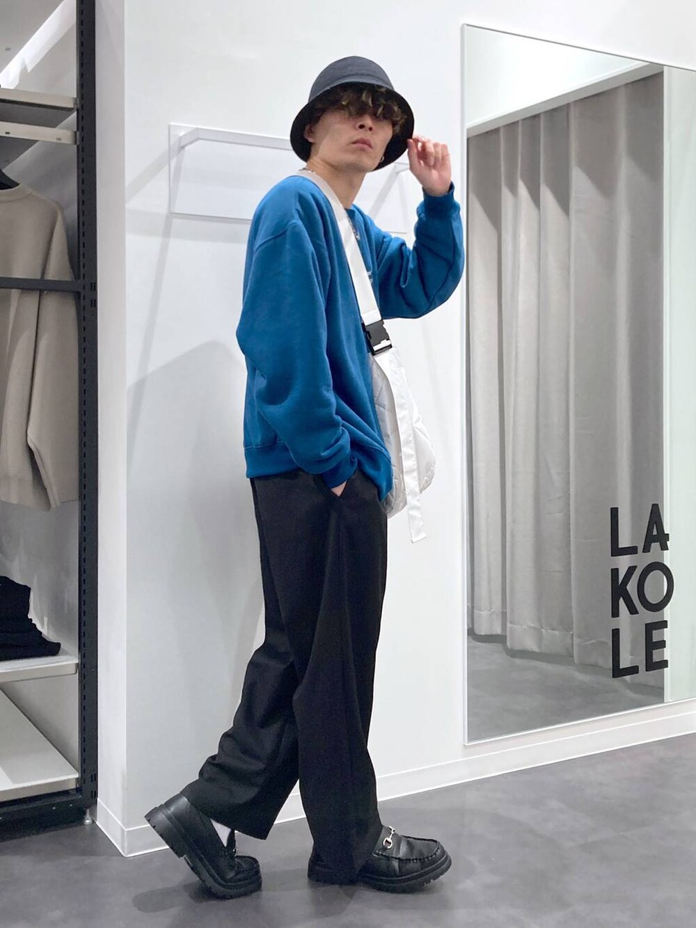 ブラック系のローファー、グリーン系のスウェット、ホワイト系のショルダーバッグを着用したメンズの冬コーディネートの6枚目の写真