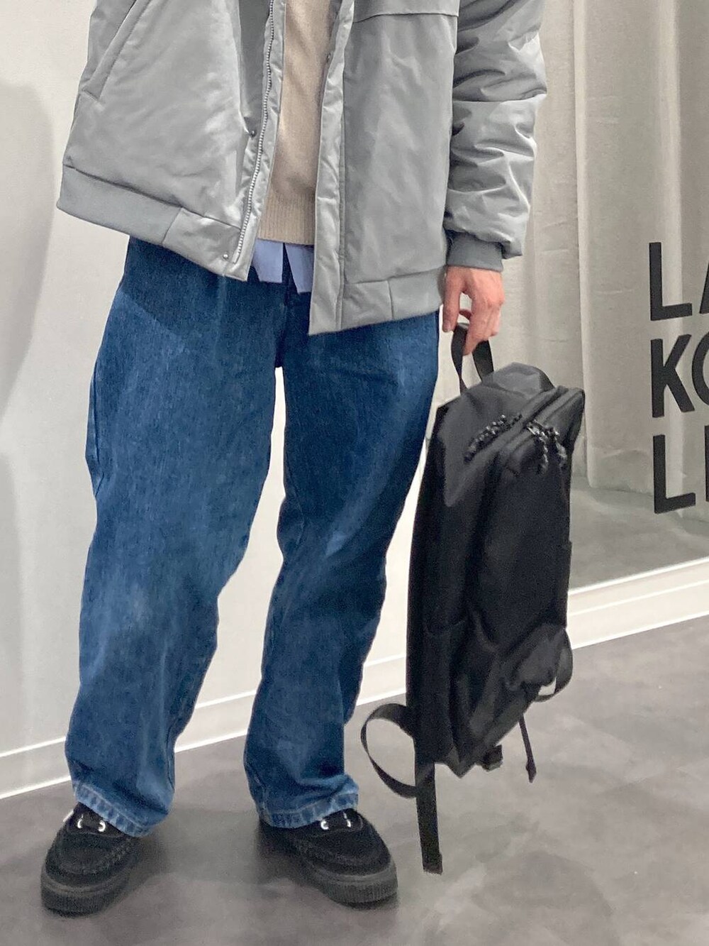 ブラック系のバックパック/リュック、ブルー系のシャツ/ブラウス、ベージュ系のニット/セーターを着用したメンズの冬コーディネートの9枚目の写真