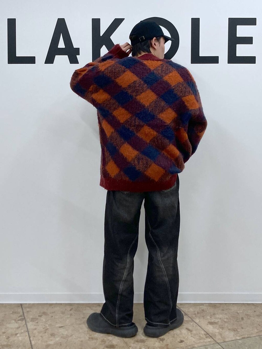 オレンジ系のカーディガン/ボレロ、グレー系のTシャツ/カットソー、ブラック系のデニムパンツを着用したメンズの冬コーディネートの2枚目の写真