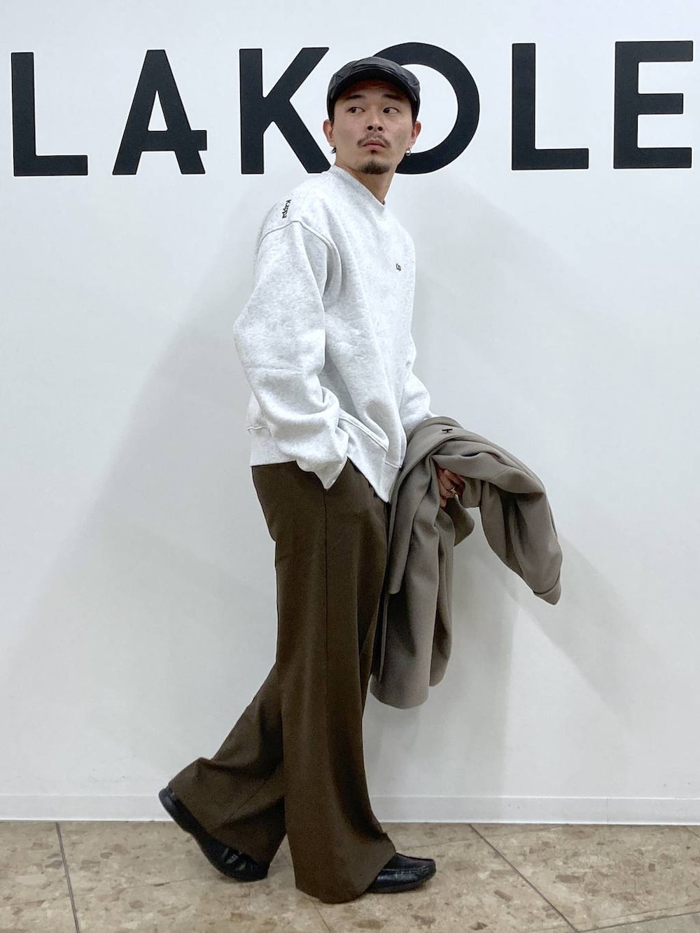 ホワイト系のチェスターコート、ブラウン系のその他パンツ、ブラック系のハンチング/ベレー帽を着用したメンズの秋コーディネートの7枚目の写真