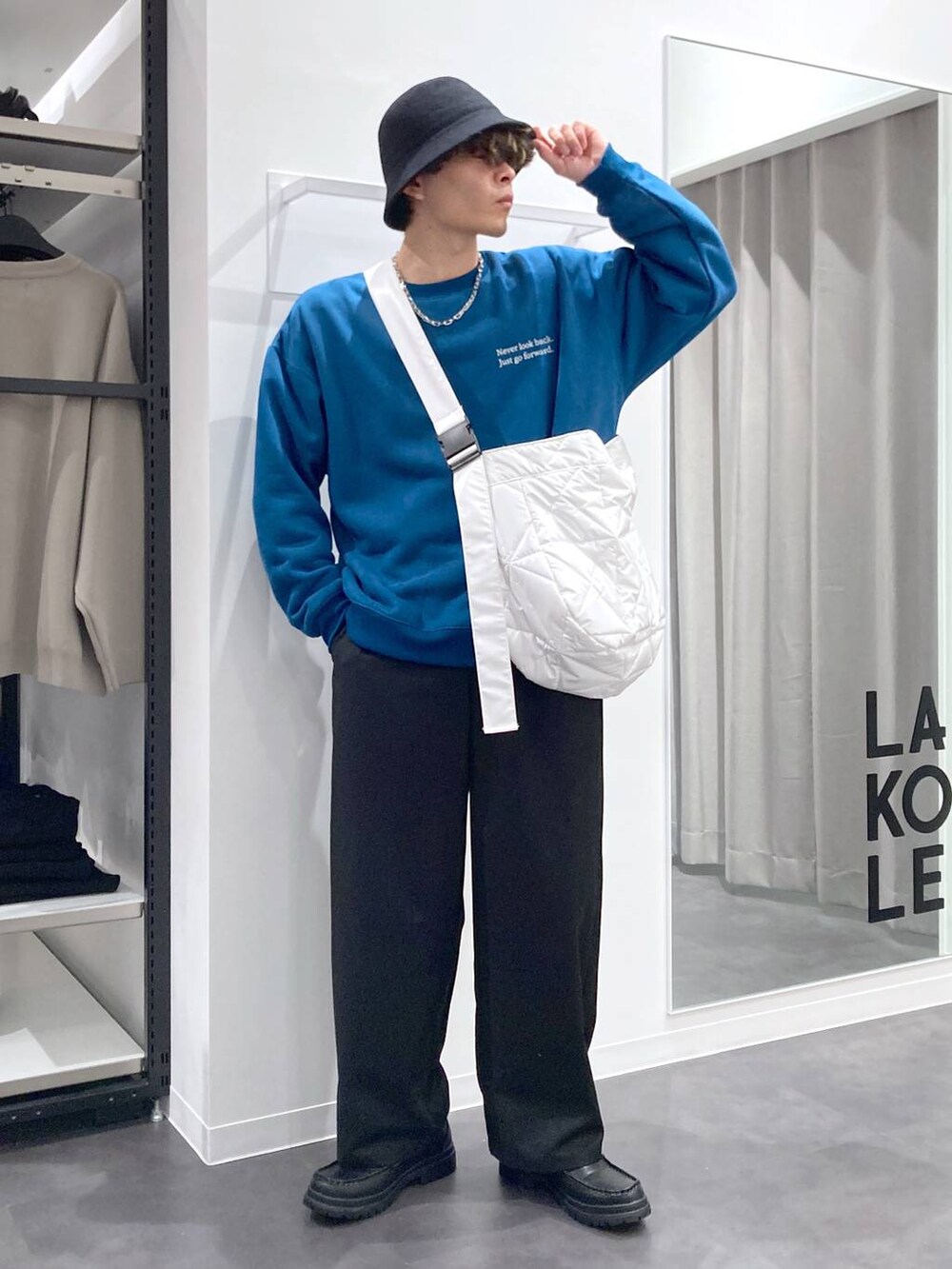 ブラック系のローファー、グリーン系のスウェット、ホワイト系のショルダーバッグを着用したメンズの冬コーディネートの8枚目の写真