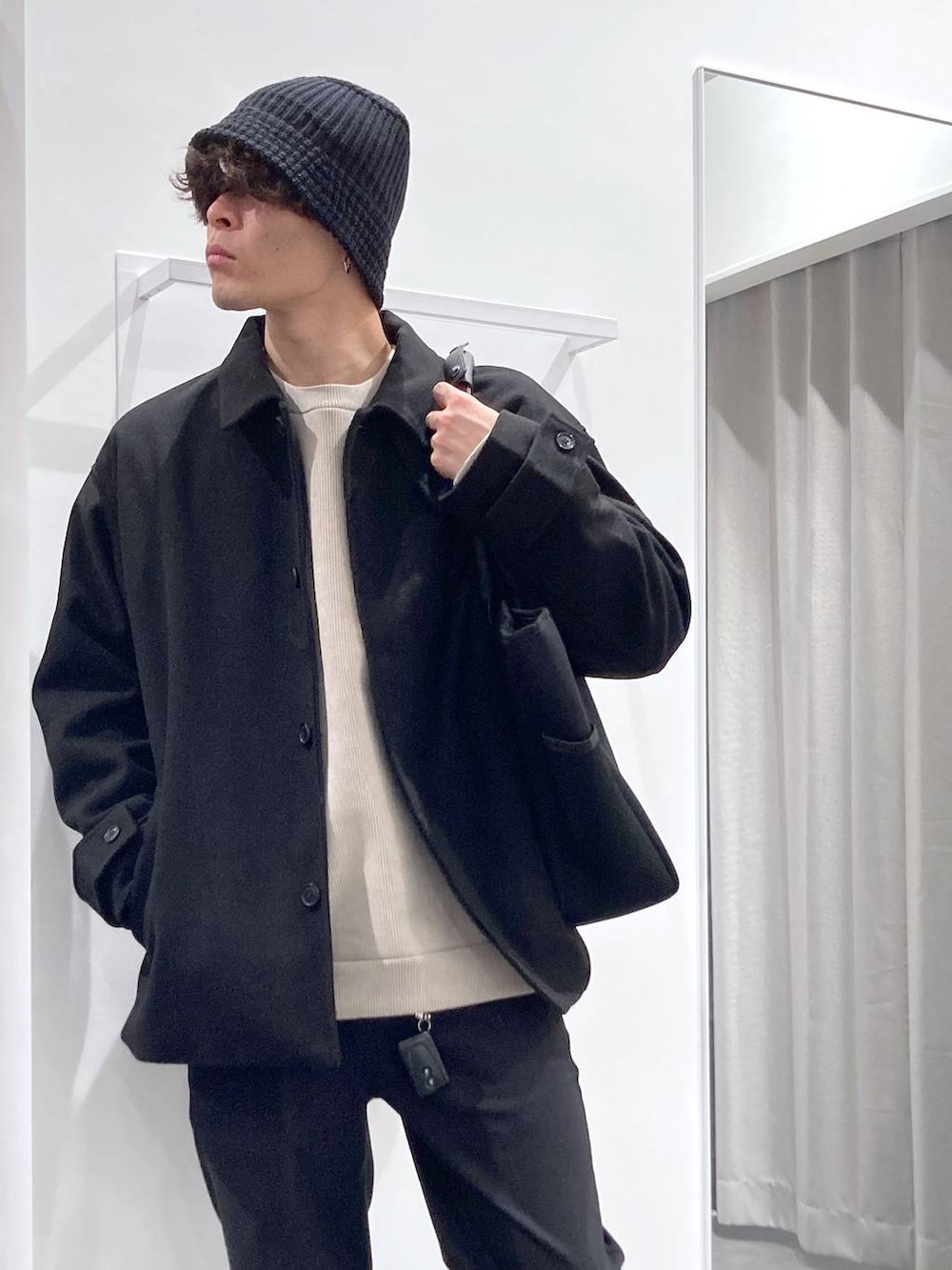 ブラック系のステンカラーコート、ブラック系のトートバッグ、ブラック系のドレスシューズを着用したメンズの冬コーディネートの4枚目の写真