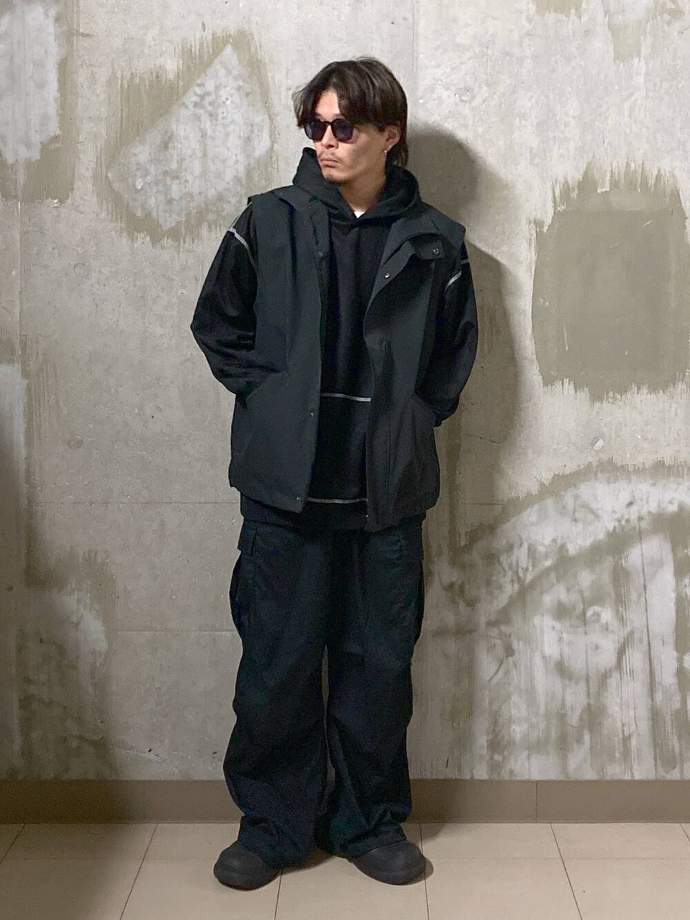 ブラック系のTシャツ/カットソー、ブラック系のカーゴパンツ、ブラック系のブルゾンを着用したメンズの秋コーディネートの5枚目の写真