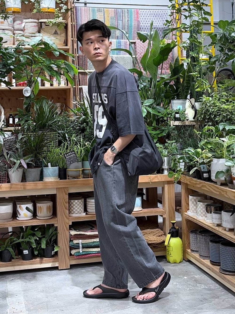 ブラック系のTシャツ/カットソー、ブラック系のエコバッグ/サブバッグ、ブラック系のサンダルを着用したメンズの夏コーディネートの4枚目の写真