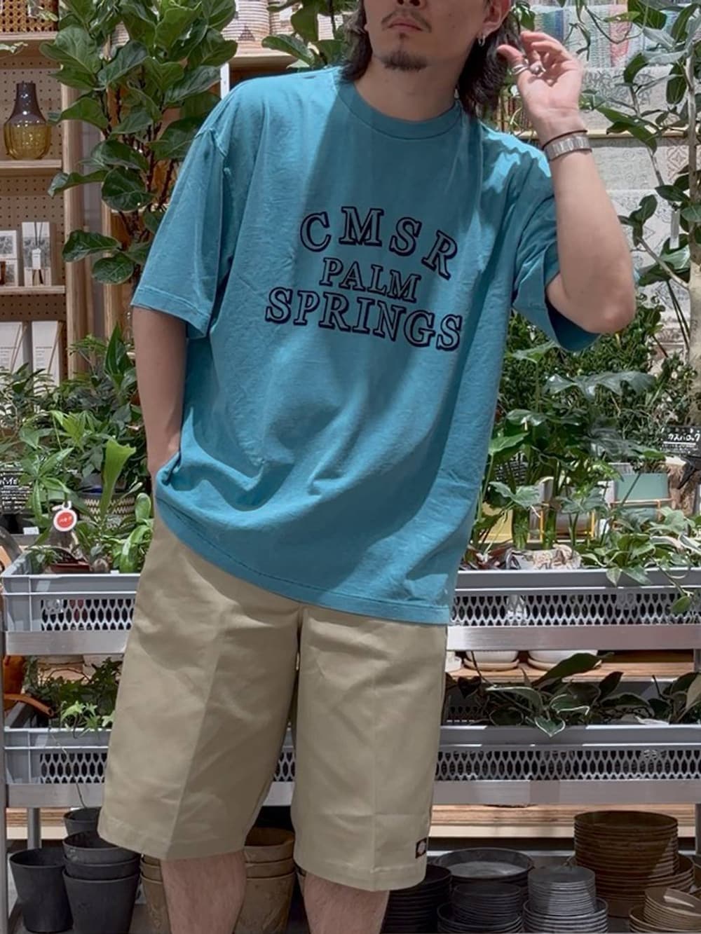 グリーン系のTシャツ/カットソー、ブルー系のスポーツグッズ、ベージュ系のキャップを着用したメンズの夏コーディネートの6枚目の写真