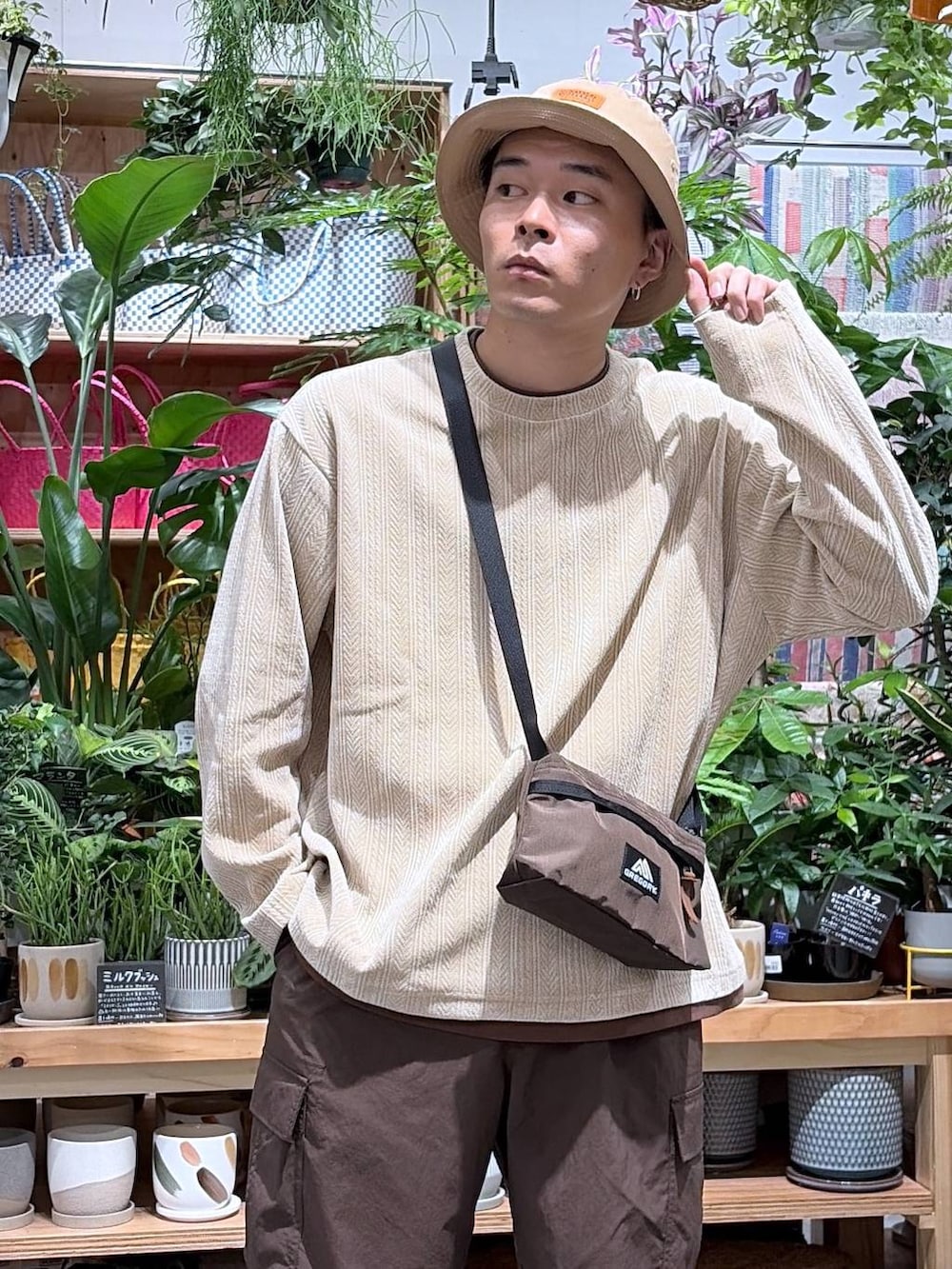ベージュ系のTシャツ/カットソー、ブラウン系のカーゴパンツ、ベージュ系のハットを着用したメンズの秋コーディネートの7枚目の写真