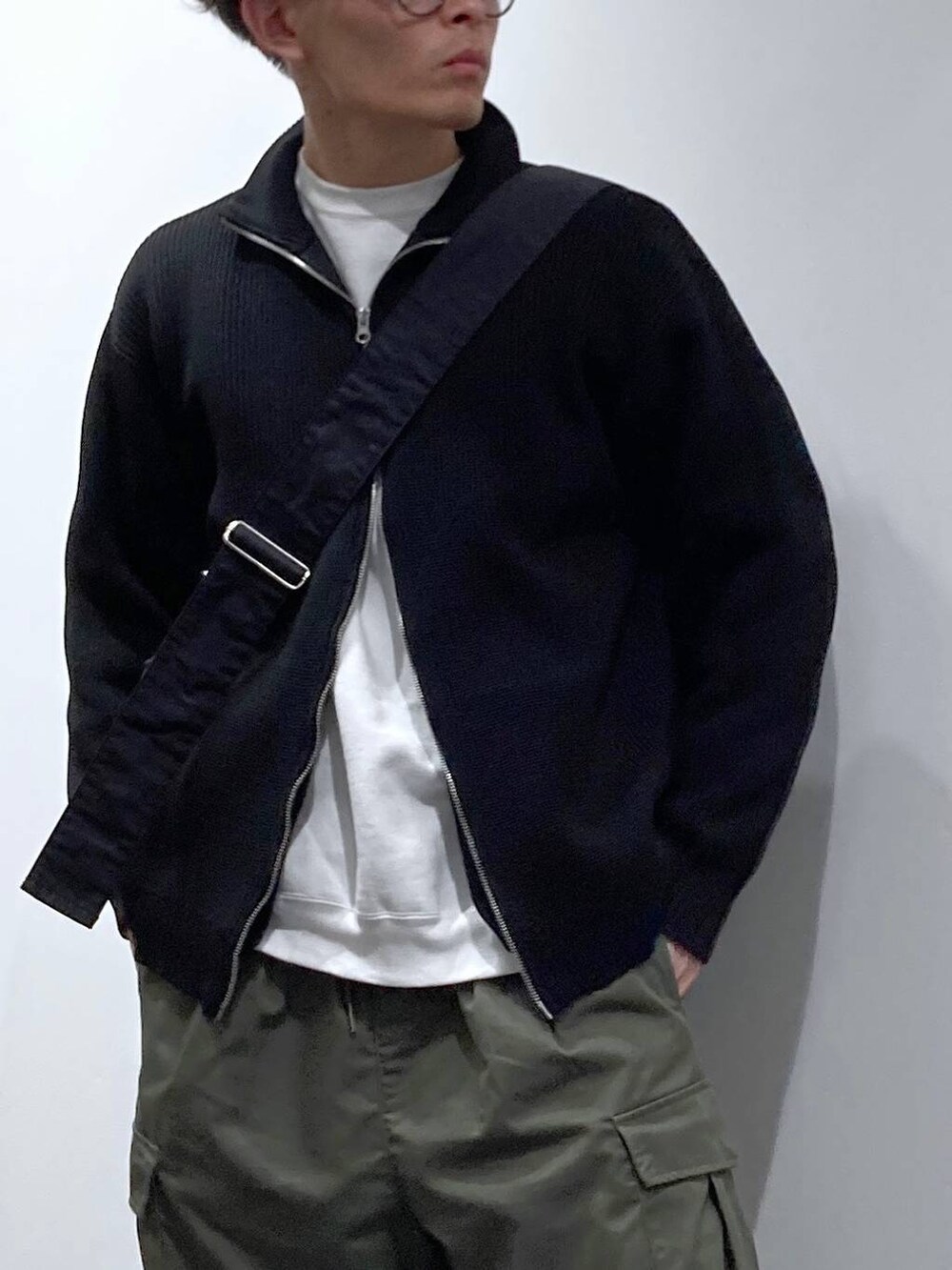 ホワイト系のスニーカー、ホワイト系のスウェット、グリーン系のカーゴパンツを着用したメンズの秋コーディネートの4枚目の写真