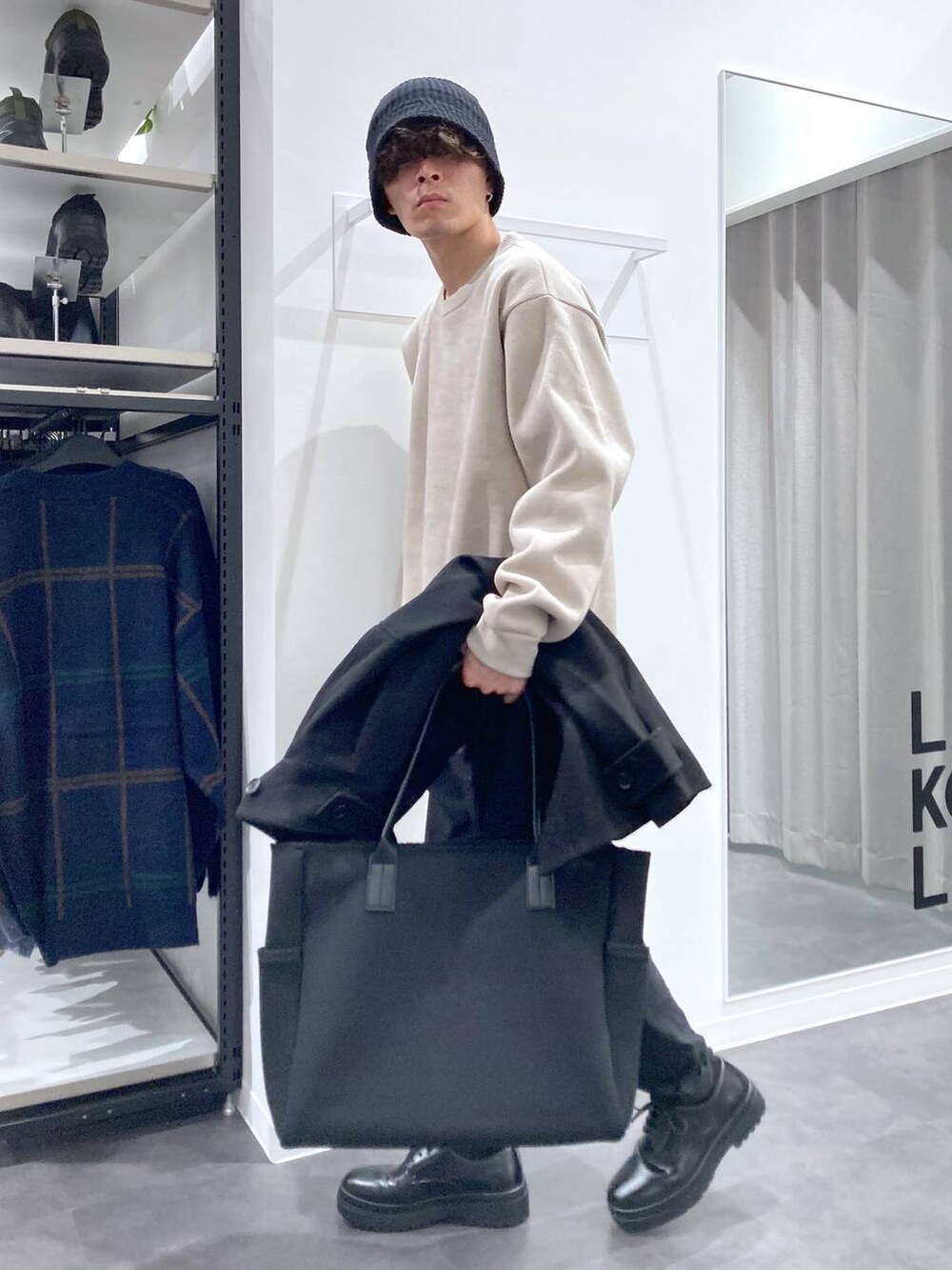 ブラック系のステンカラーコート、ブラック系のトートバッグ、ブラック系のドレスシューズを着用したメンズの冬コーディネートの5枚目の写真