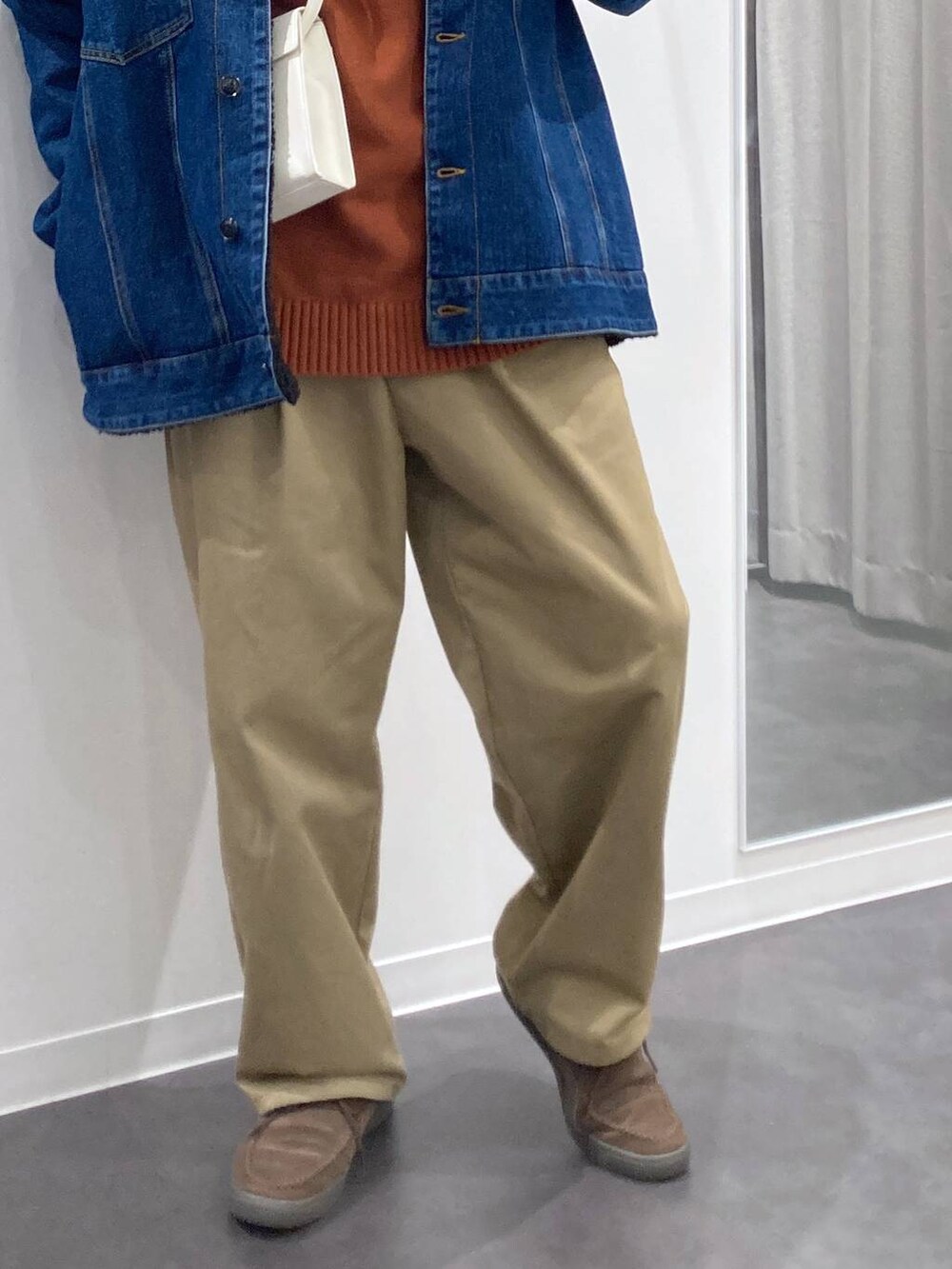 ブルー系のデニムジャケット、ベージュ系のチノパンツ、オレンジ系のニット/セーターを着用したメンズの冬コーディネートの7枚目の写真