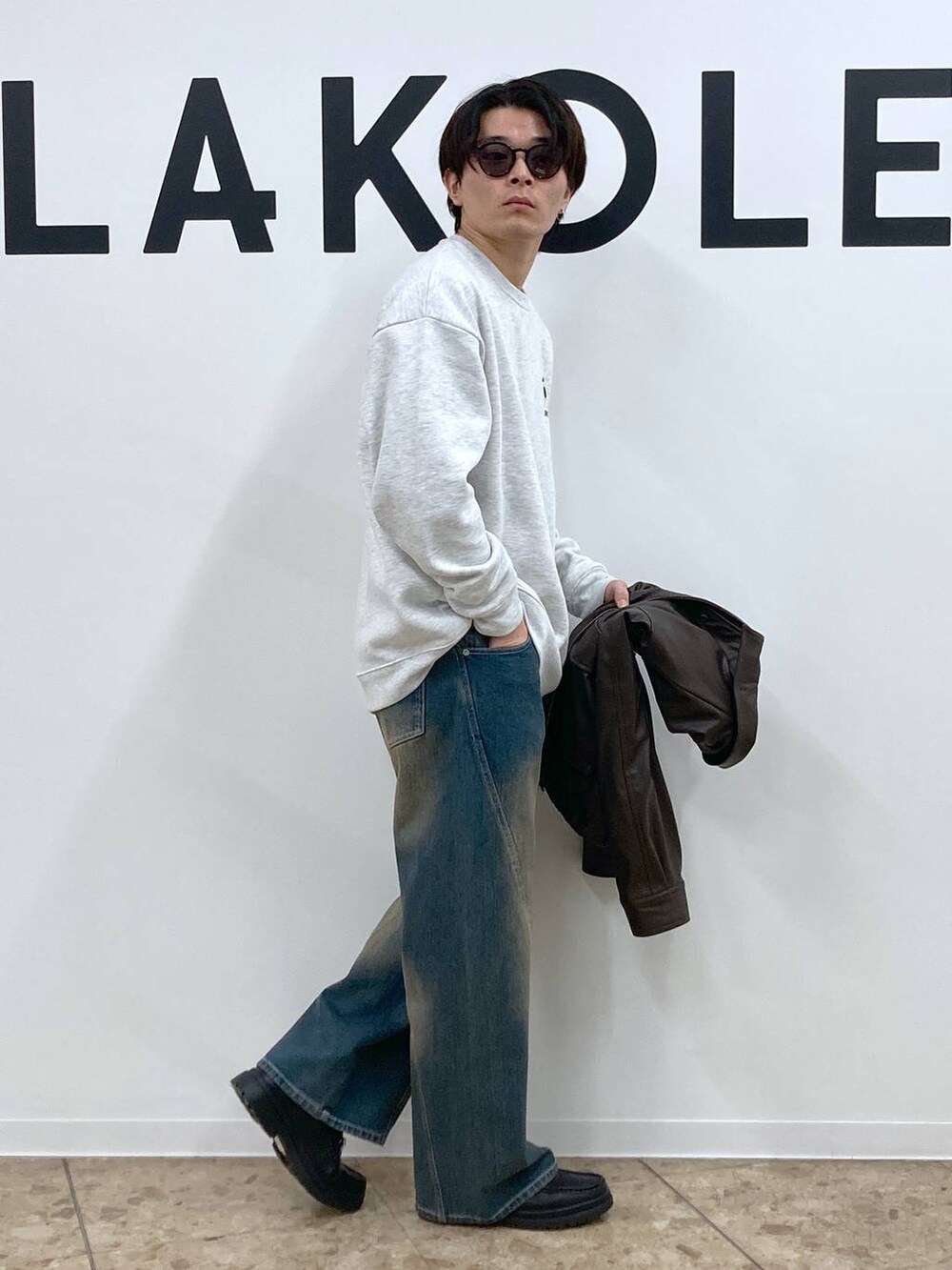 ブルー系のデニムパンツ、グレー系のスウェット、ブラック系のローファーを着用したメンズの冬コーディネートの3枚目の写真