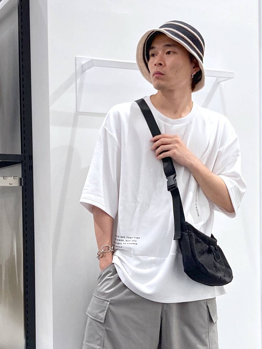 ブラック系のサンダル、ホワイト系のTシャツ/カットソー、ブラック系のショルダーバッグを着用したメンズの夏コーディネートの5枚目の写真