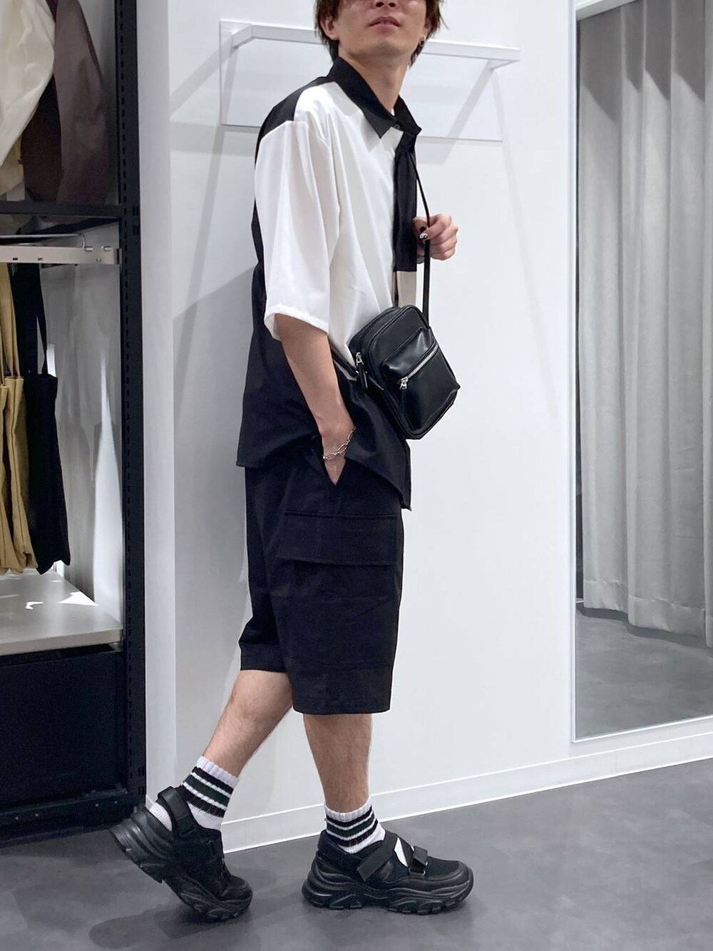 ブラック系のスニーカー、ホワイト系のTシャツ/カットソー、ブラック系のショルダーバッグを着用したメンズの夏コーディネートの4枚目の写真