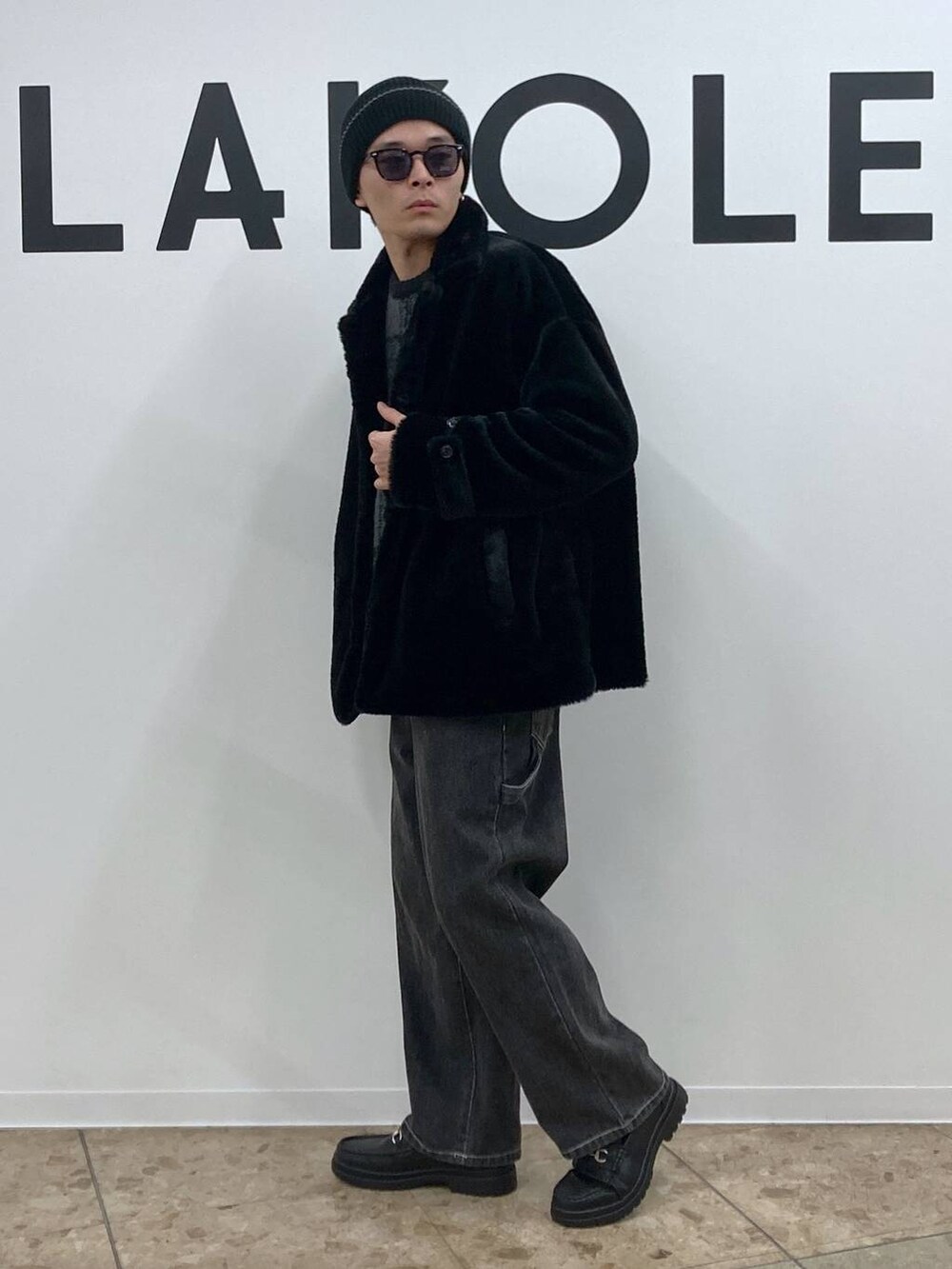 ブラック系のニット/セーター、グレー系のデニムパンツ、ブラック系のローファーを着用したメンズの冬コーディネートの3枚目の写真