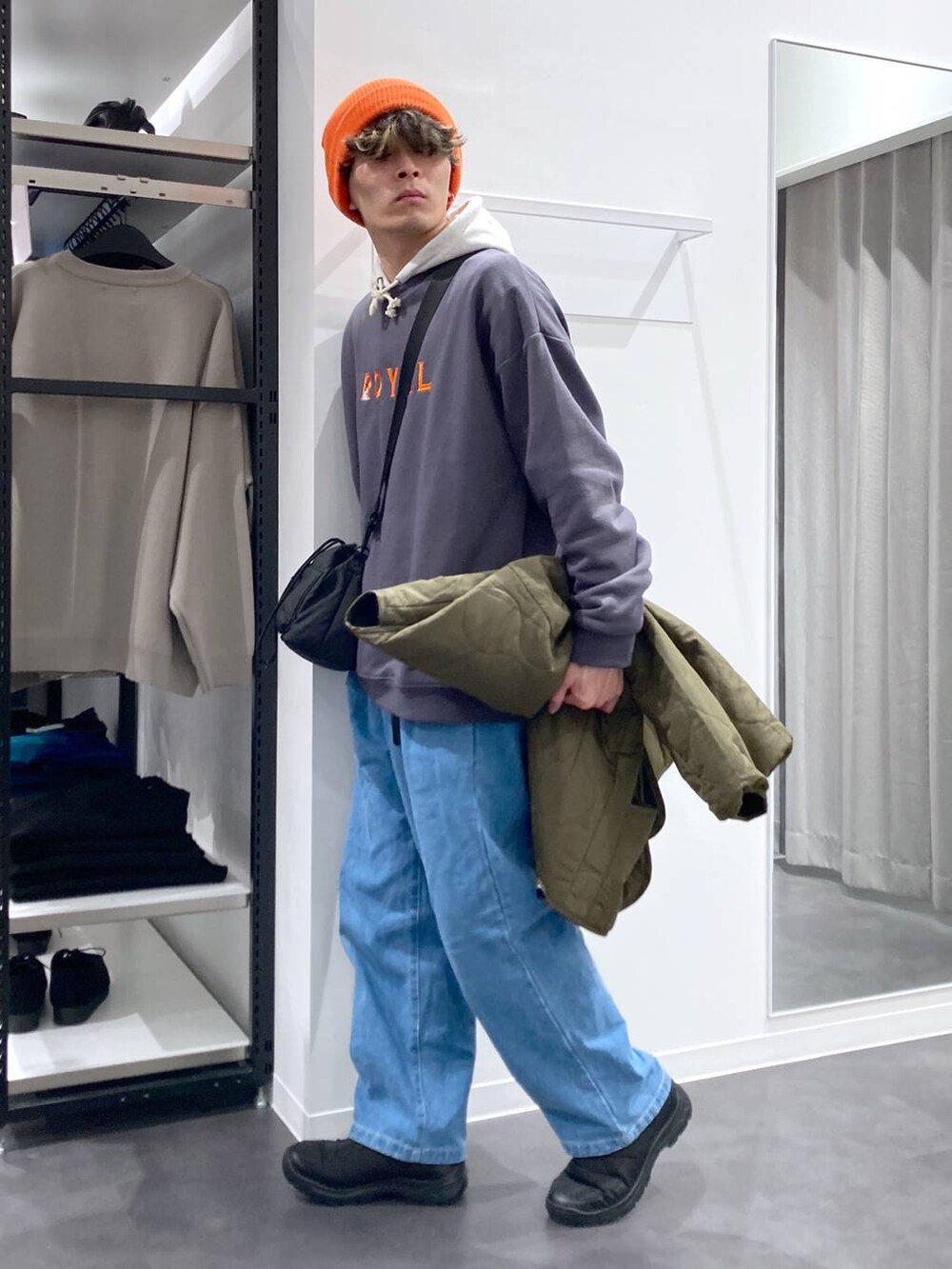 ホワイト系のパーカー、ブラック系のショルダーバッグ、グリーン系のブルゾンを着用したメンズの冬コーディネートの5枚目の写真