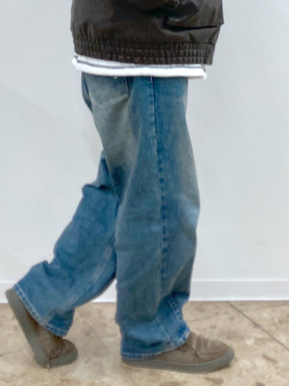 ブルー系のデニムパンツ、ホワイト系のTシャツ/カットソー、ブラウン系のブルゾンを着用したメンズの秋コーディネートの9枚目の写真