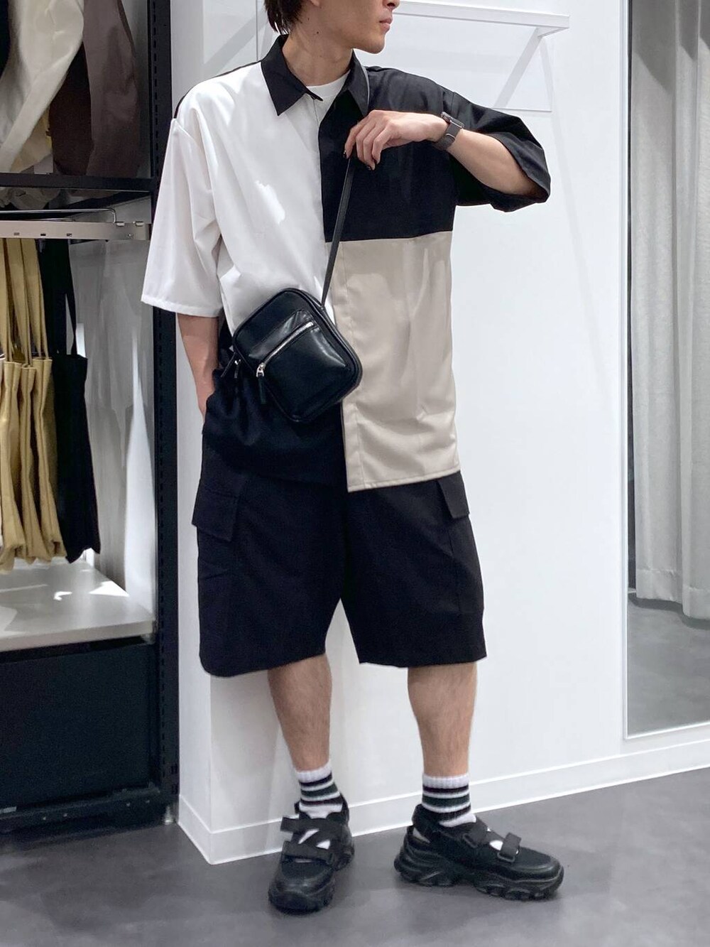 ブラック系のスニーカー、ホワイト系のTシャツ/カットソー、ブラック系のショルダーバッグを着用したメンズの夏コーディネートの7枚目の写真