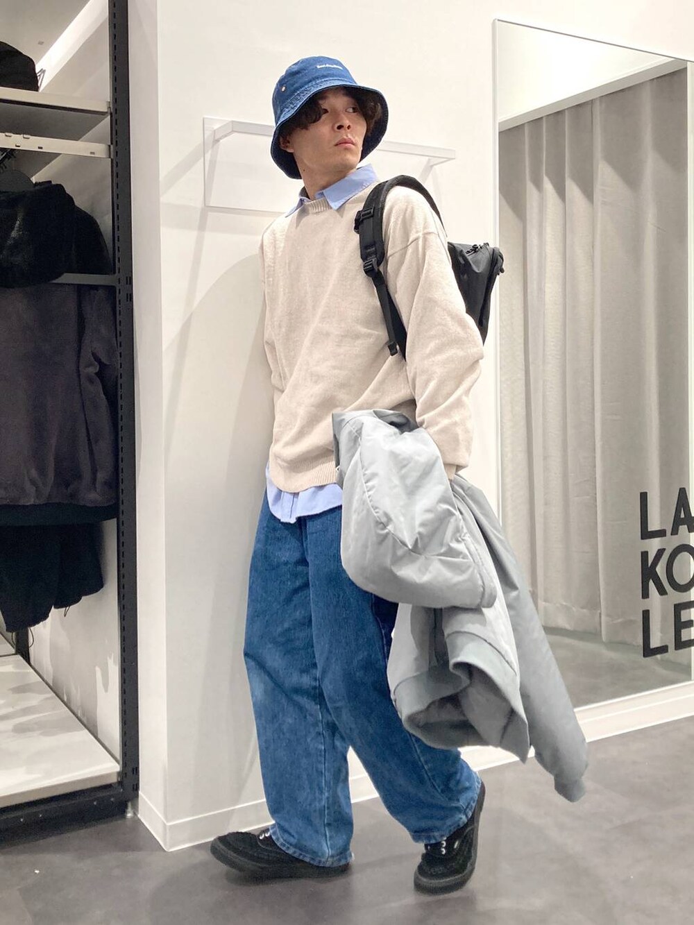 ブラック系のバックパック/リュック、ブルー系のシャツ/ブラウス、ベージュ系のニット/セーターを着用したメンズの冬コーディネートの7枚目の写真