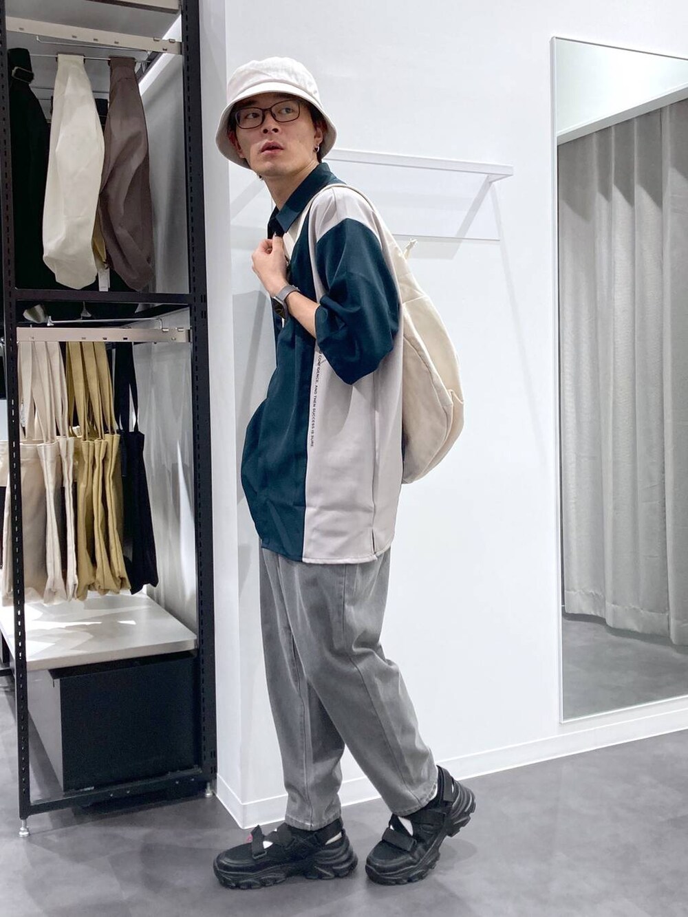 ブラック系のスニーカー、ベージュ系のショルダーバッグ、グリーン系のシャツ/ブラウスを着用したメンズの夏コーディネートの3枚目の写真