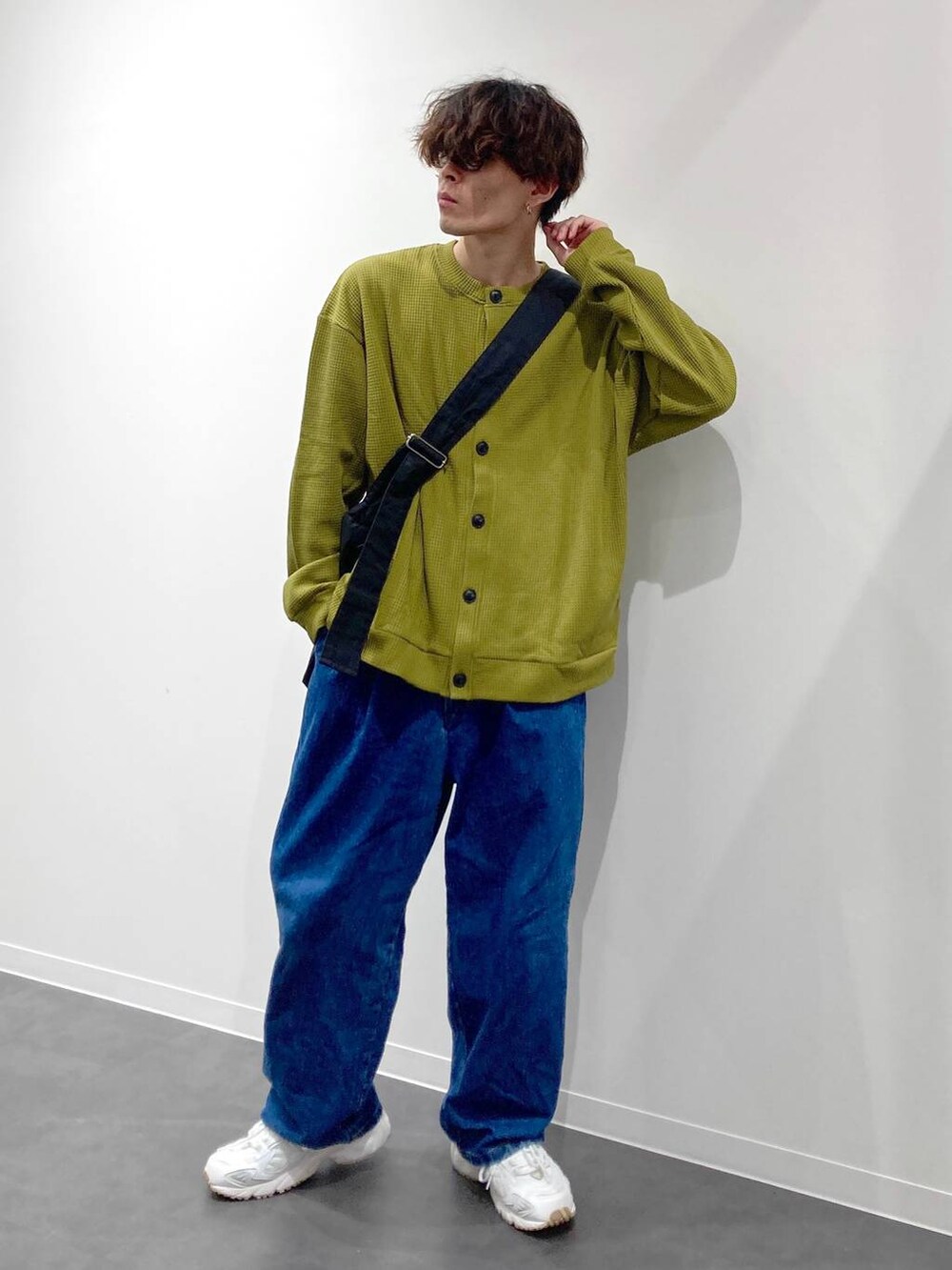 ホワイト系のスニーカー、イエロー系のTシャツ/カットソー、ブルー系のデニムパンツを着用したメンズの秋コーディネートの4枚目の写真