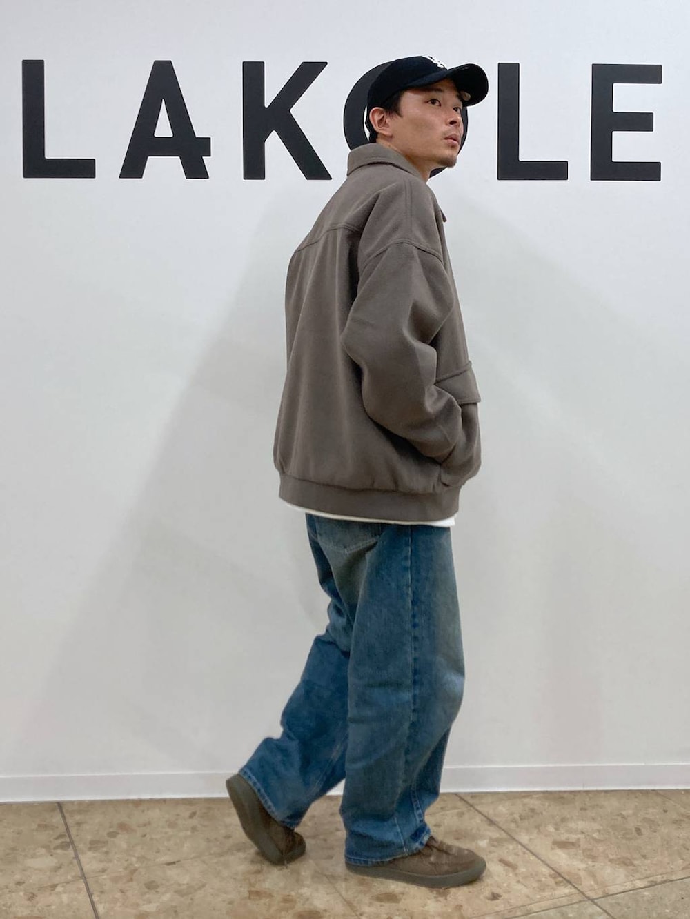 ブラウン系のブルゾン、ブルー系のデニムパンツ、ホワイト系のTシャツ/カットソーを着用したメンズの秋コーディネートの4枚目の写真