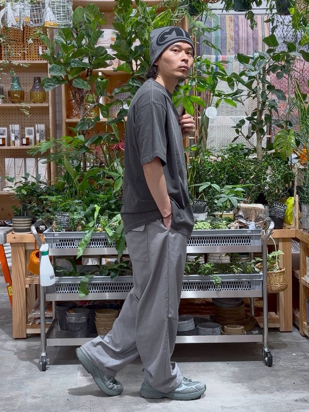 グレー系のスラックス、ブラック系のTシャツ/カットソーを着用したメンズの夏コーディネートの3枚目の写真