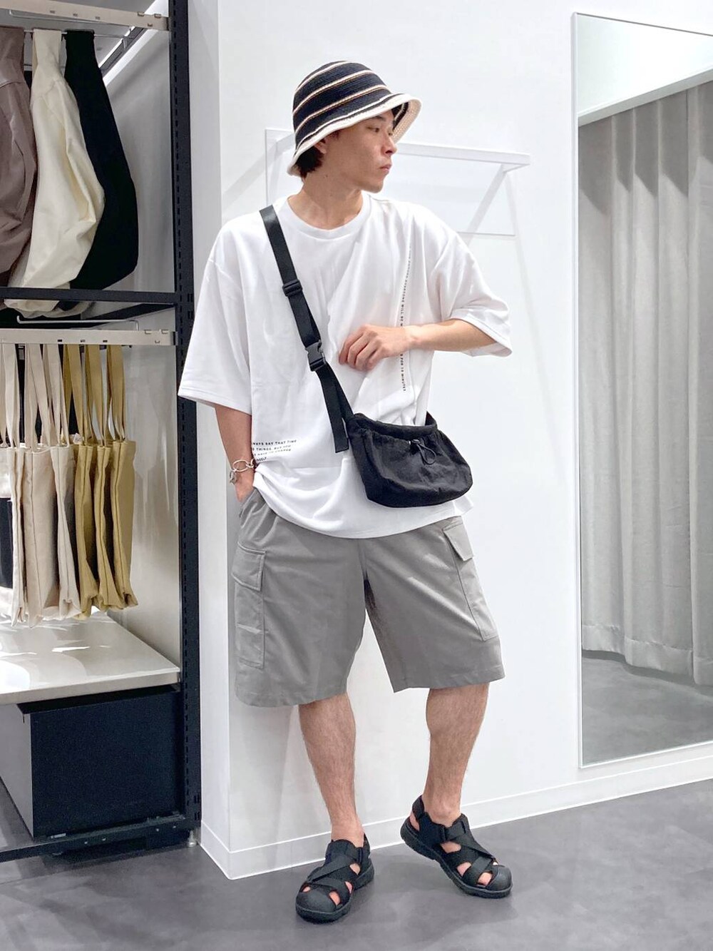 ブラック系のサンダル、ホワイト系のTシャツ/カットソー、ブラック系のショルダーバッグを着用したメンズの夏コーディネートの4枚目の写真