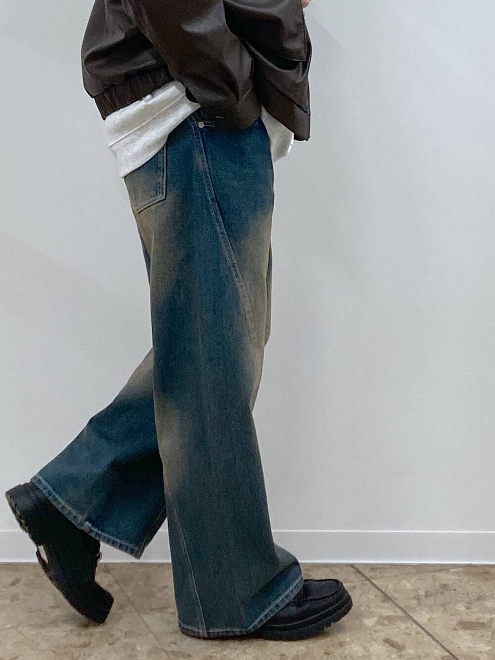 ブルー系のデニムパンツ、グレー系のスウェット、ブラック系のローファーを着用したメンズの冬コーディネートの9枚目の写真