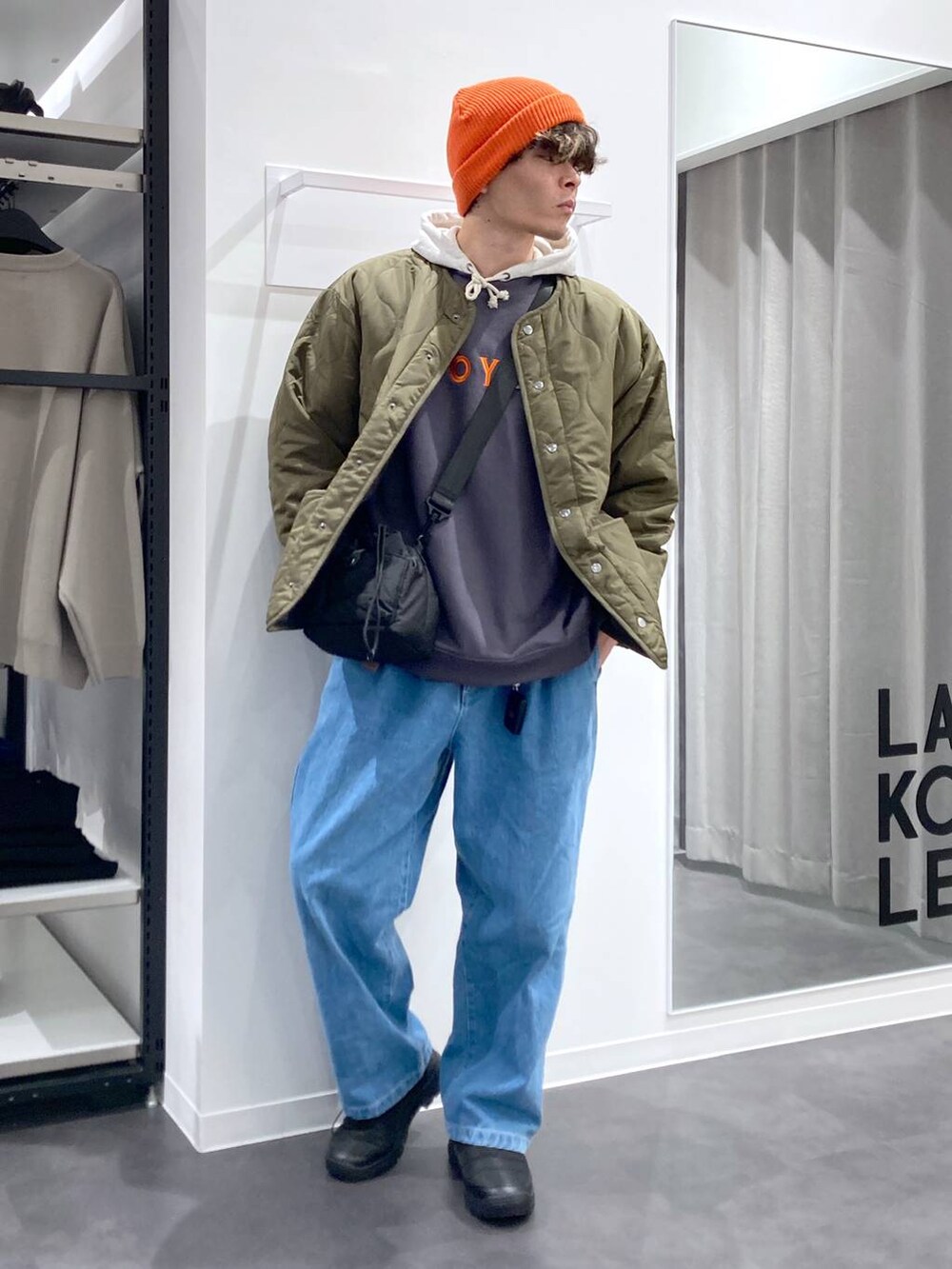 ホワイト系のパーカー、ブラック系のショルダーバッグ、グリーン系のブルゾンを着用したメンズの冬コーディネートの4枚目の写真