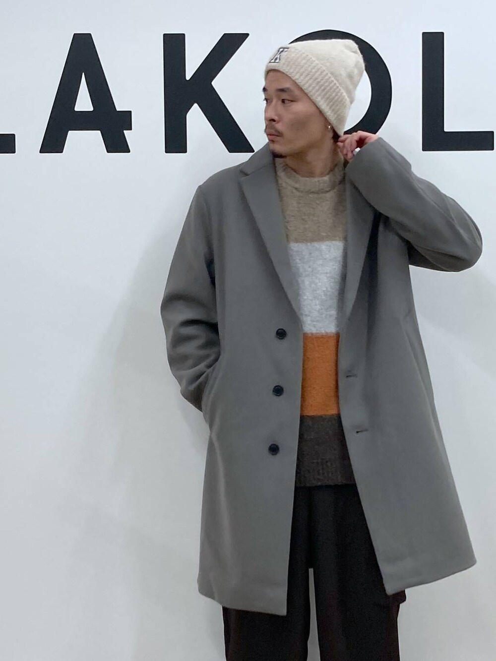 グレー系のチェスターコート、ブラウン系のカーゴパンツ、ブラウン系のニット/セーターを着用したメンズの冬コーディネートの8枚目の写真